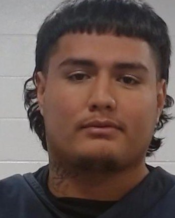Young man with short dark hair and a neck tattoo in a law enforcement booking photo.