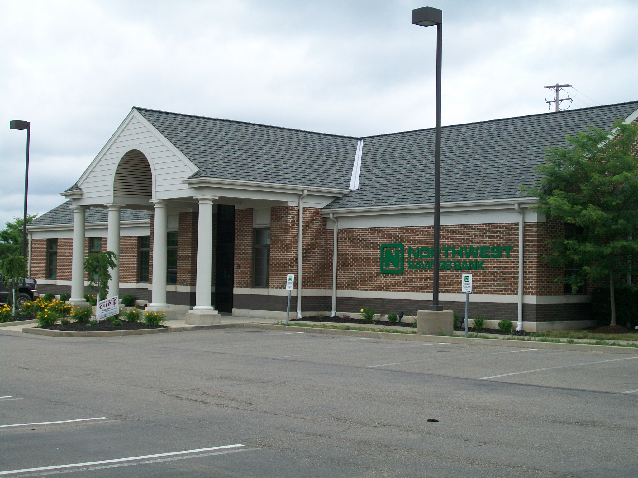 Brick bank building with white columns and green Northwest Bank signage.