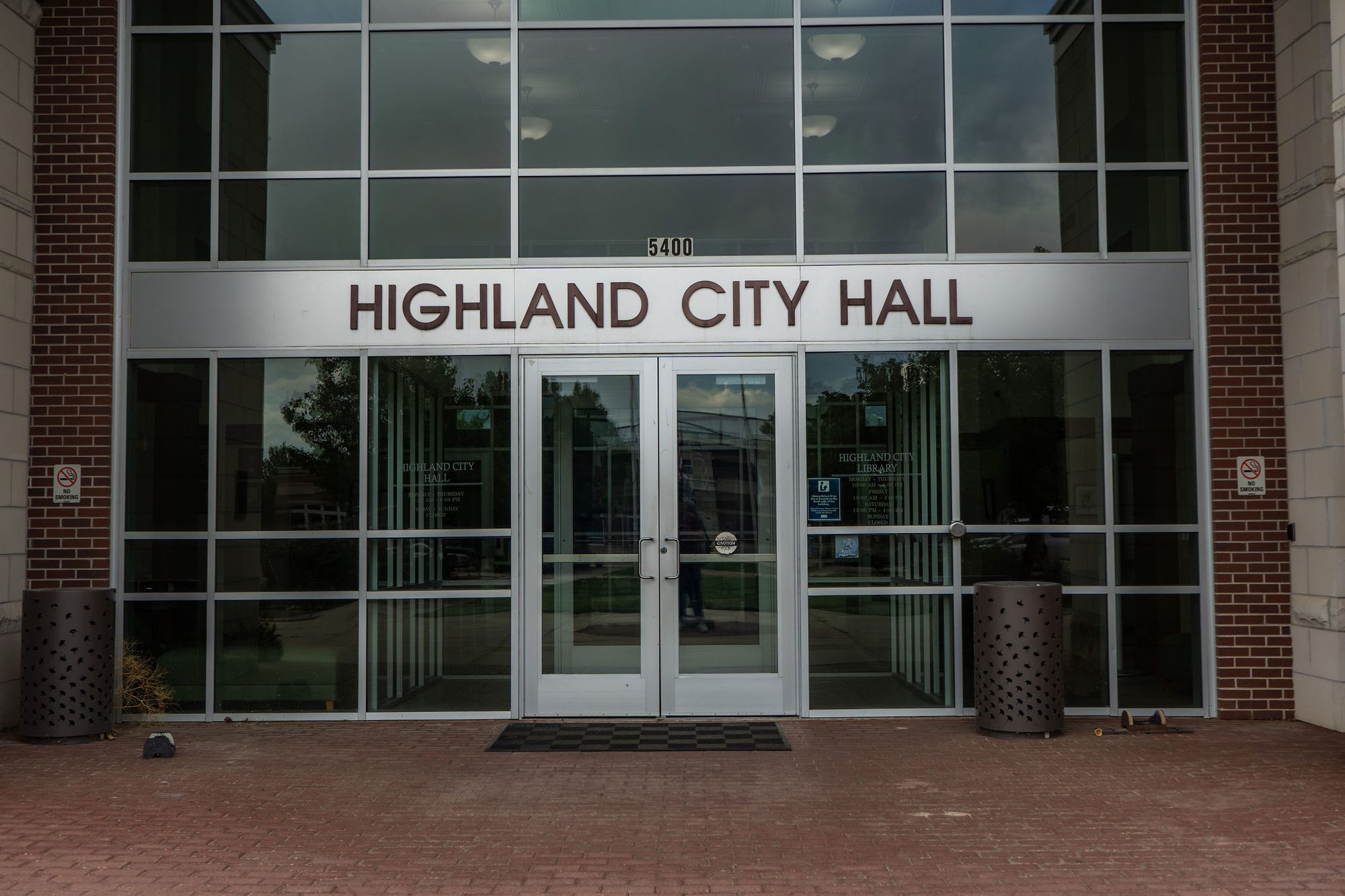 Glass and brick entrance to Highland City Hall with address signage above the doors.