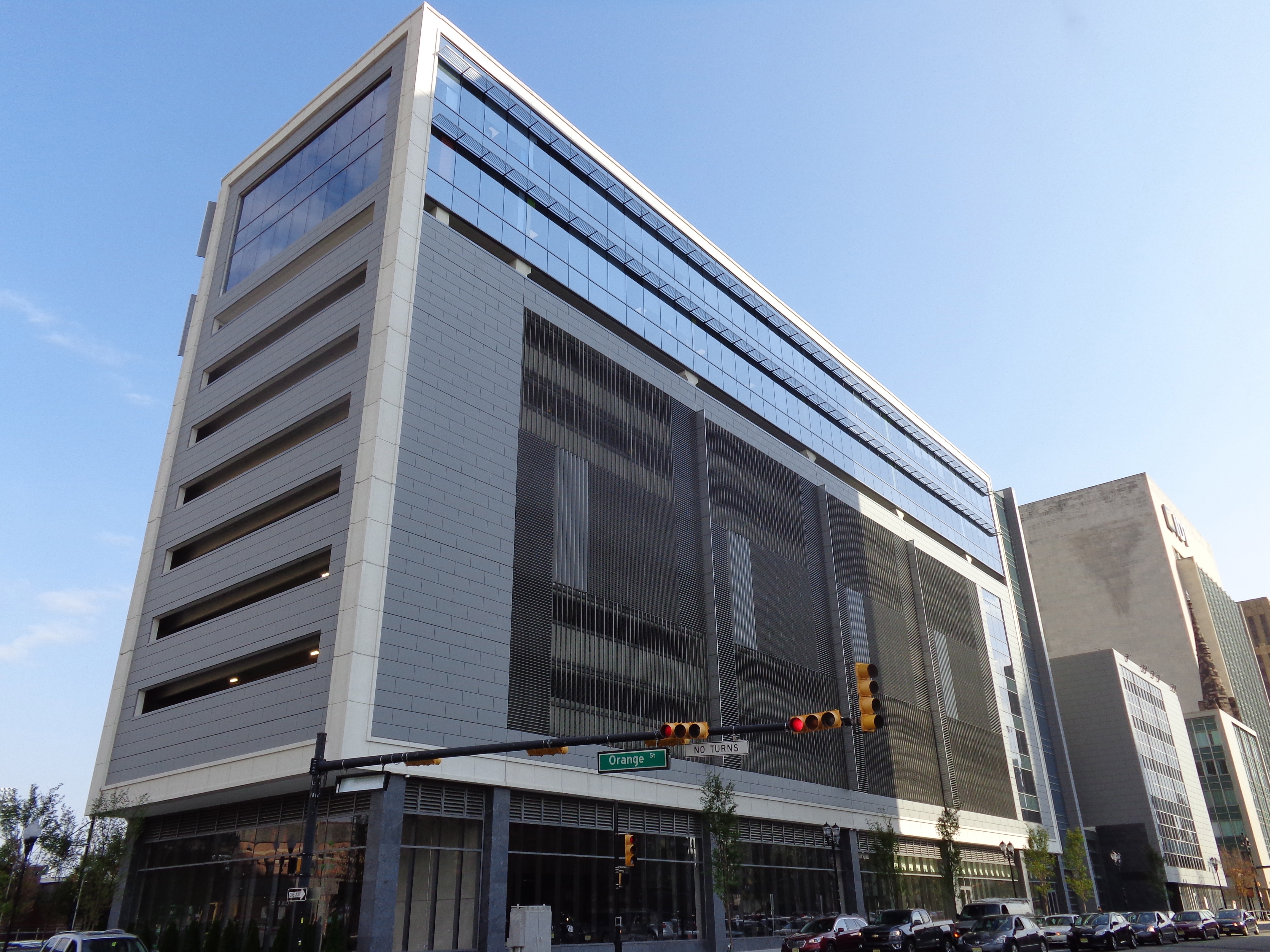 Multi-story glass and metal commercial building at a Newark street corner.