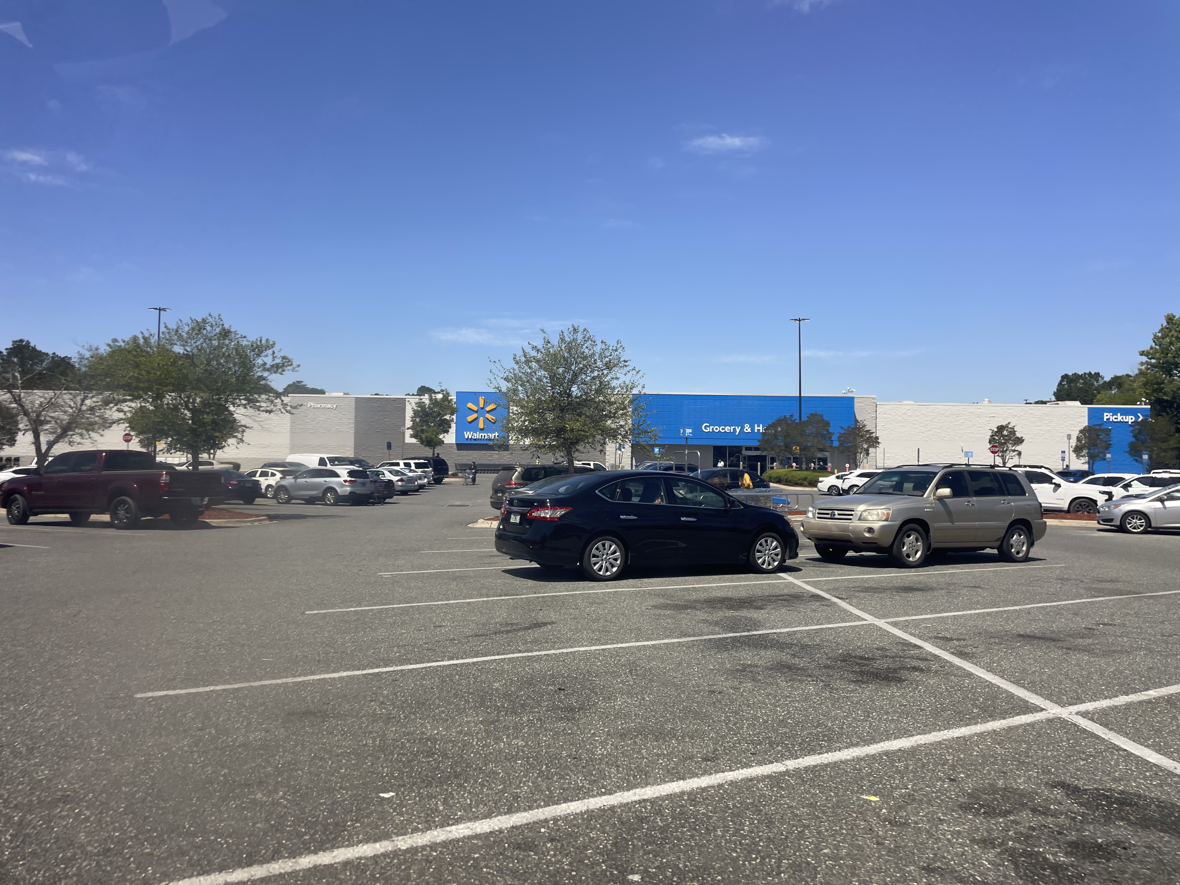 Exterior of a Walmart store with blue signage and a large parking lot.