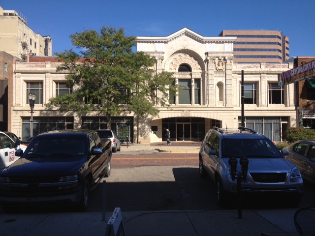Ornate two-story historic commercial building with arched entrance and decorative stonework.