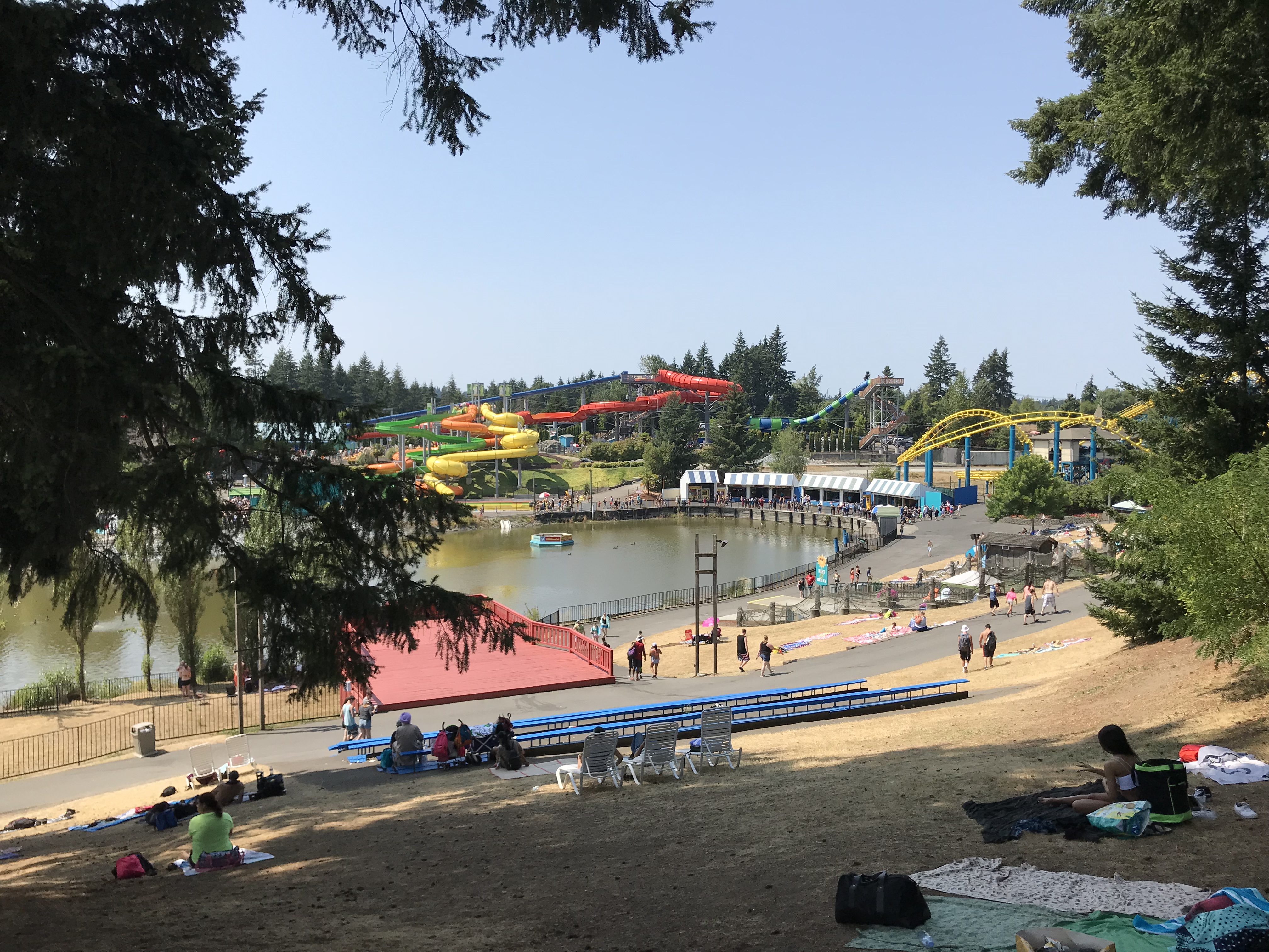 Aerial view of a water park with colorful slides, a wave pool, and a red pedestrian bridge.