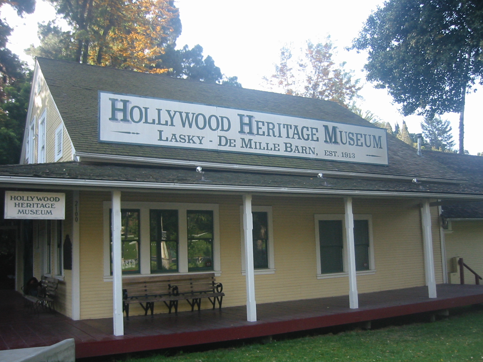Yellow wooden historic barn building with a covered front porch and white columns, housing the Hollywood Heritage Museum.