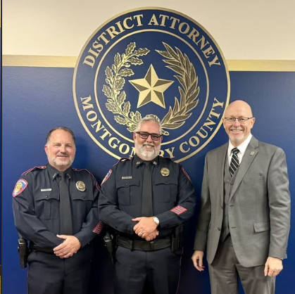 Three men pose in front of a Montgomery County District Attorney's Office seal on a blue wall.