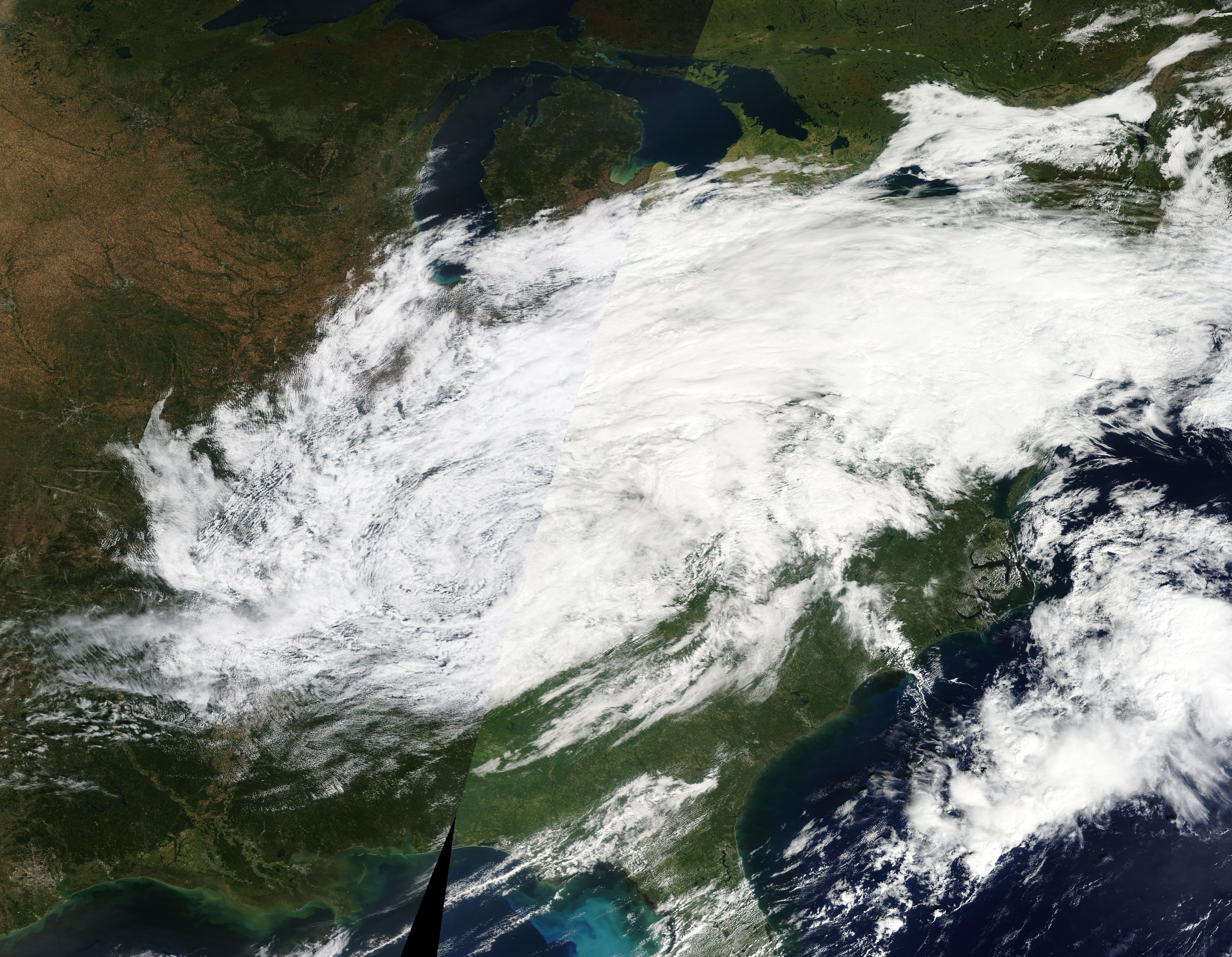 Satellite view of a broad swirling storm system blanketing the eastern United States.