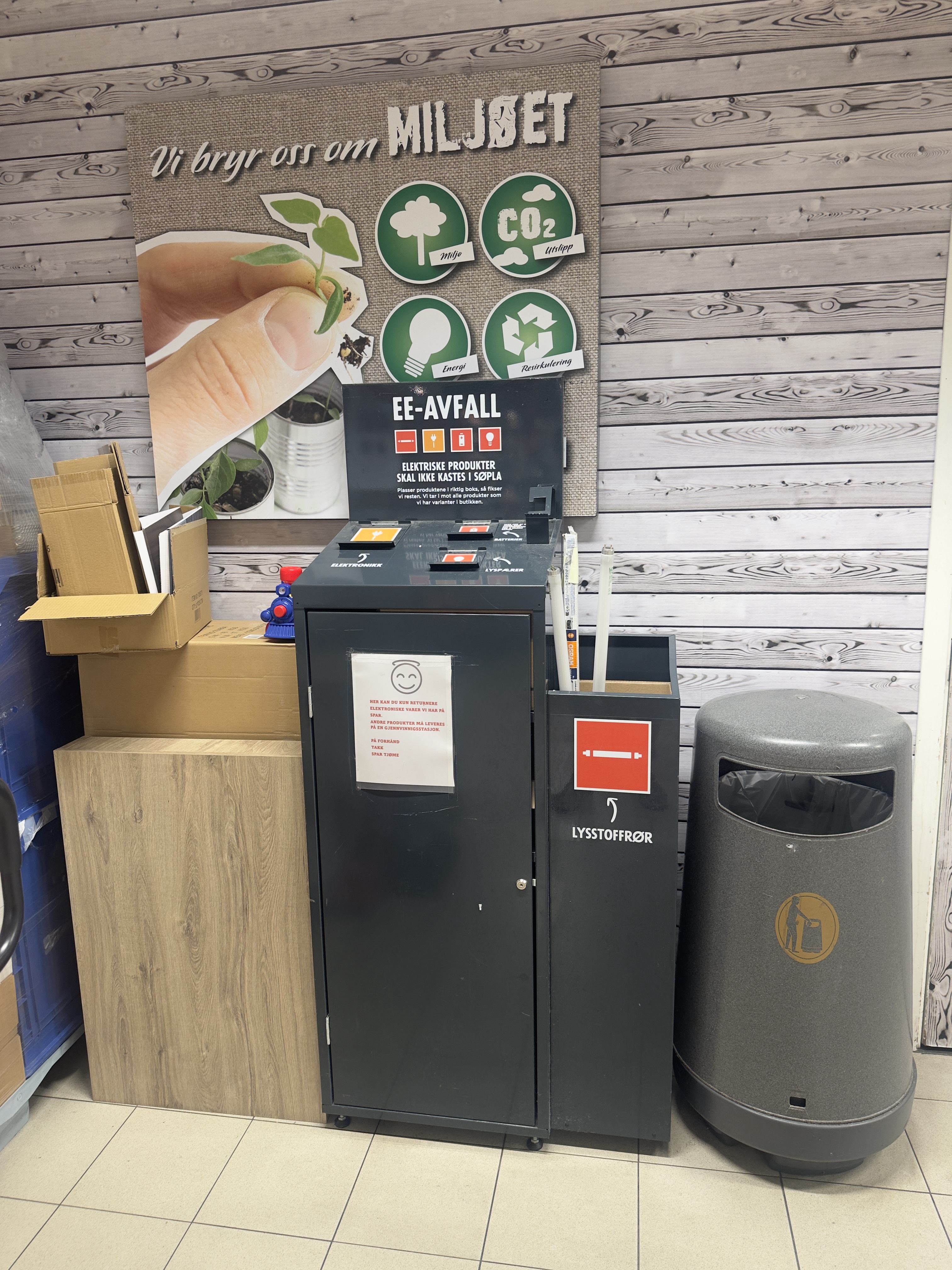 A dark metal e-waste collection cabinet with separate bins for electronics and batteries.