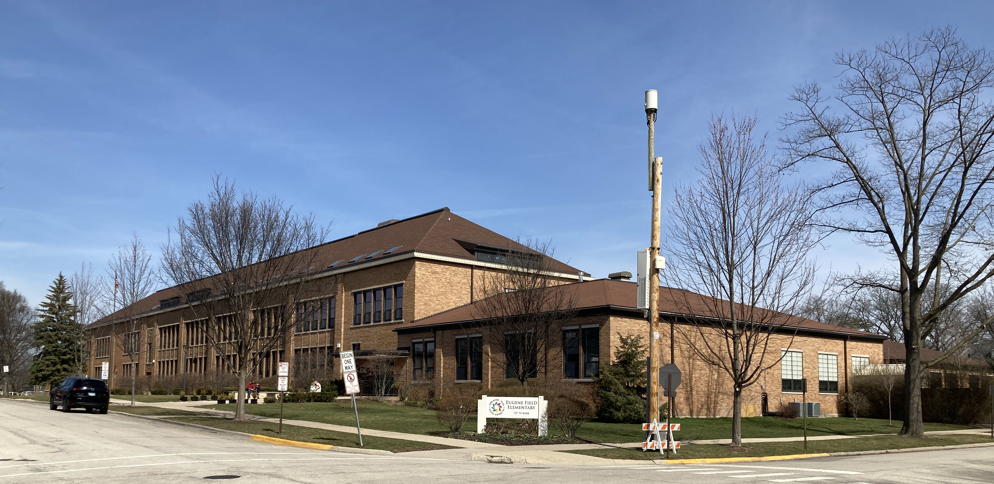 Two-story brick elementary school building on a street corner with bare trees.