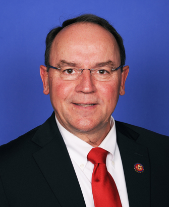 Man in dark suit and red tie with glasses in an official congressional portrait.
