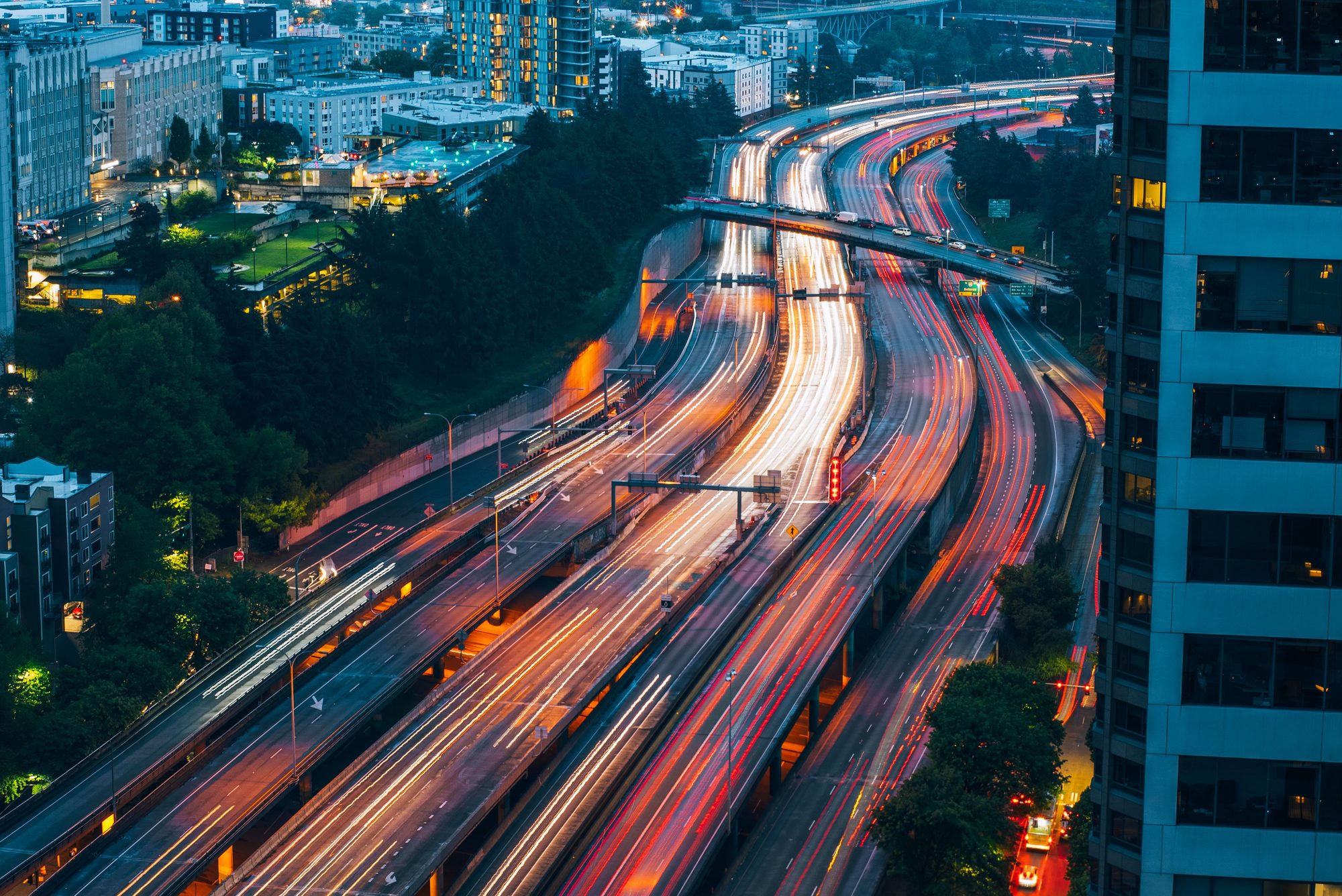 Dynamic night-time cityscape of Seattle with vibrant traffic trails, highlighting the bustling urban life.