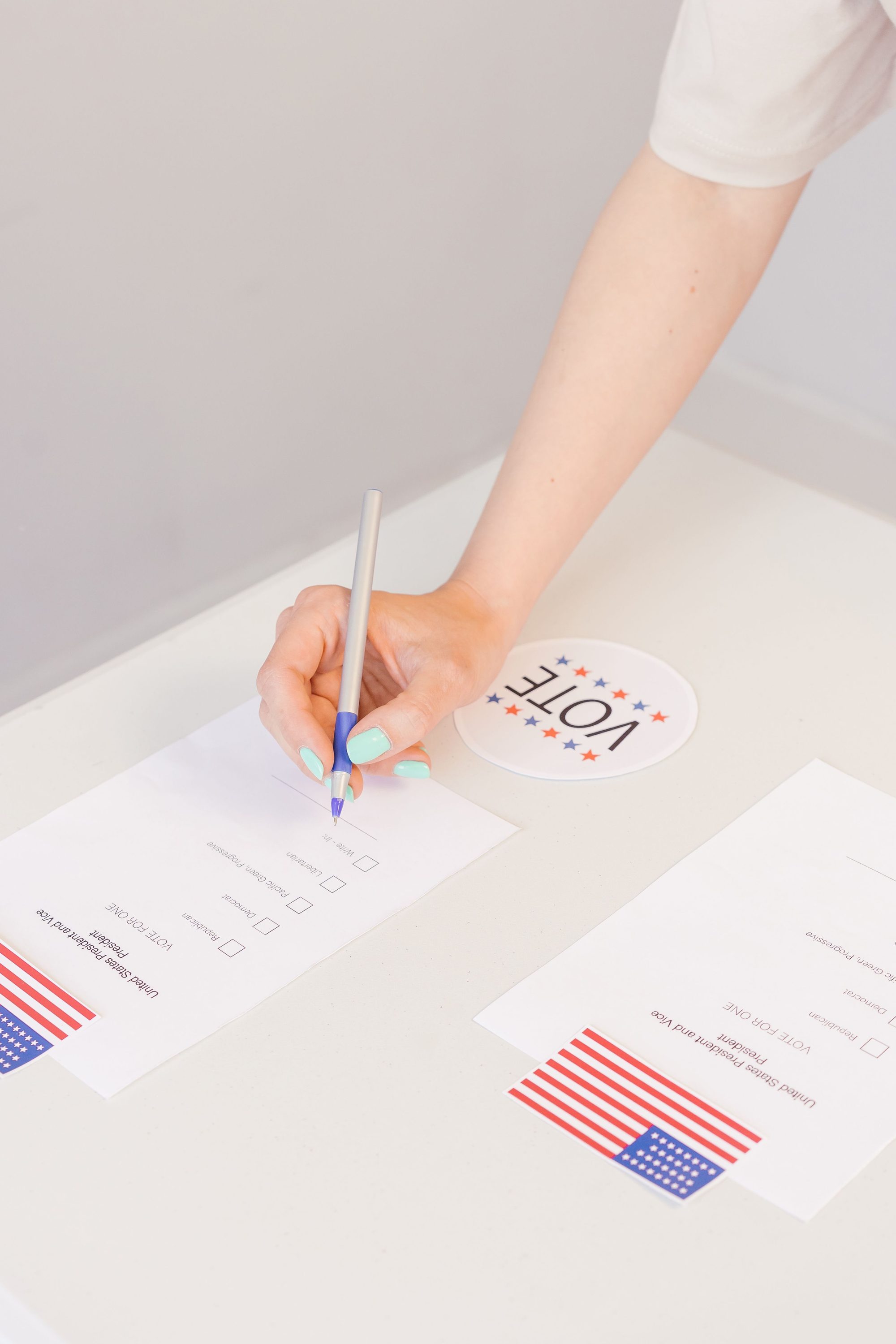 Hand filling out a voting ballot paper during an election process.
