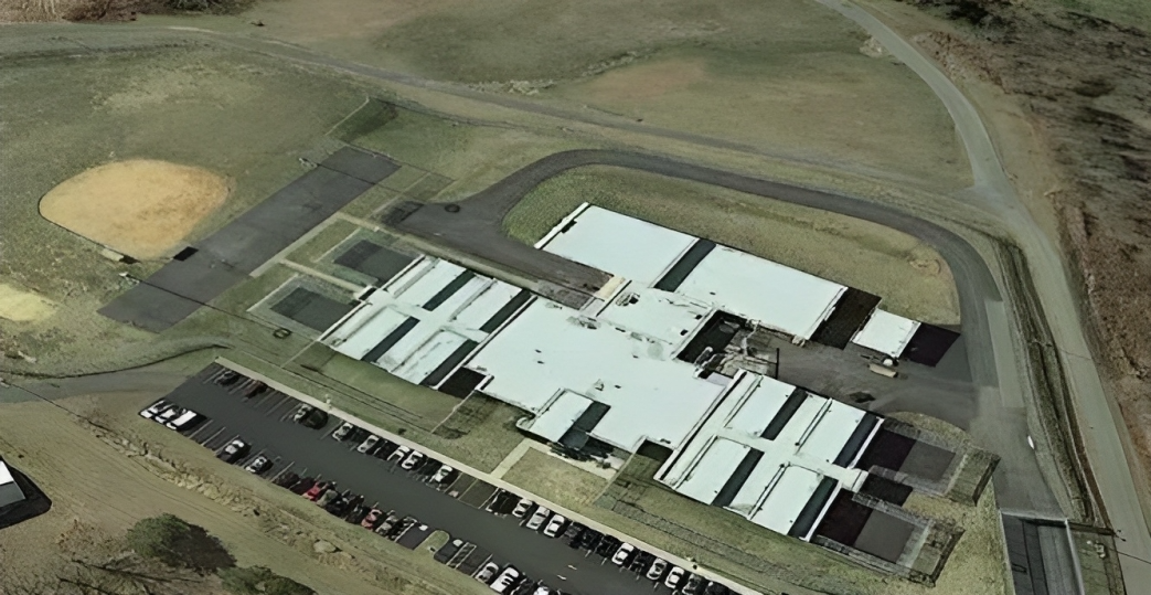 Aerial view of a juvenile detention campus with connected buildings and a perimeter road.