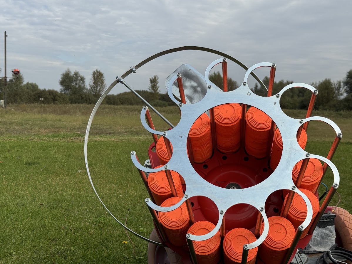 Clay target launcher (trap) loaded with orange clay targets, used in sporting clays competitions.