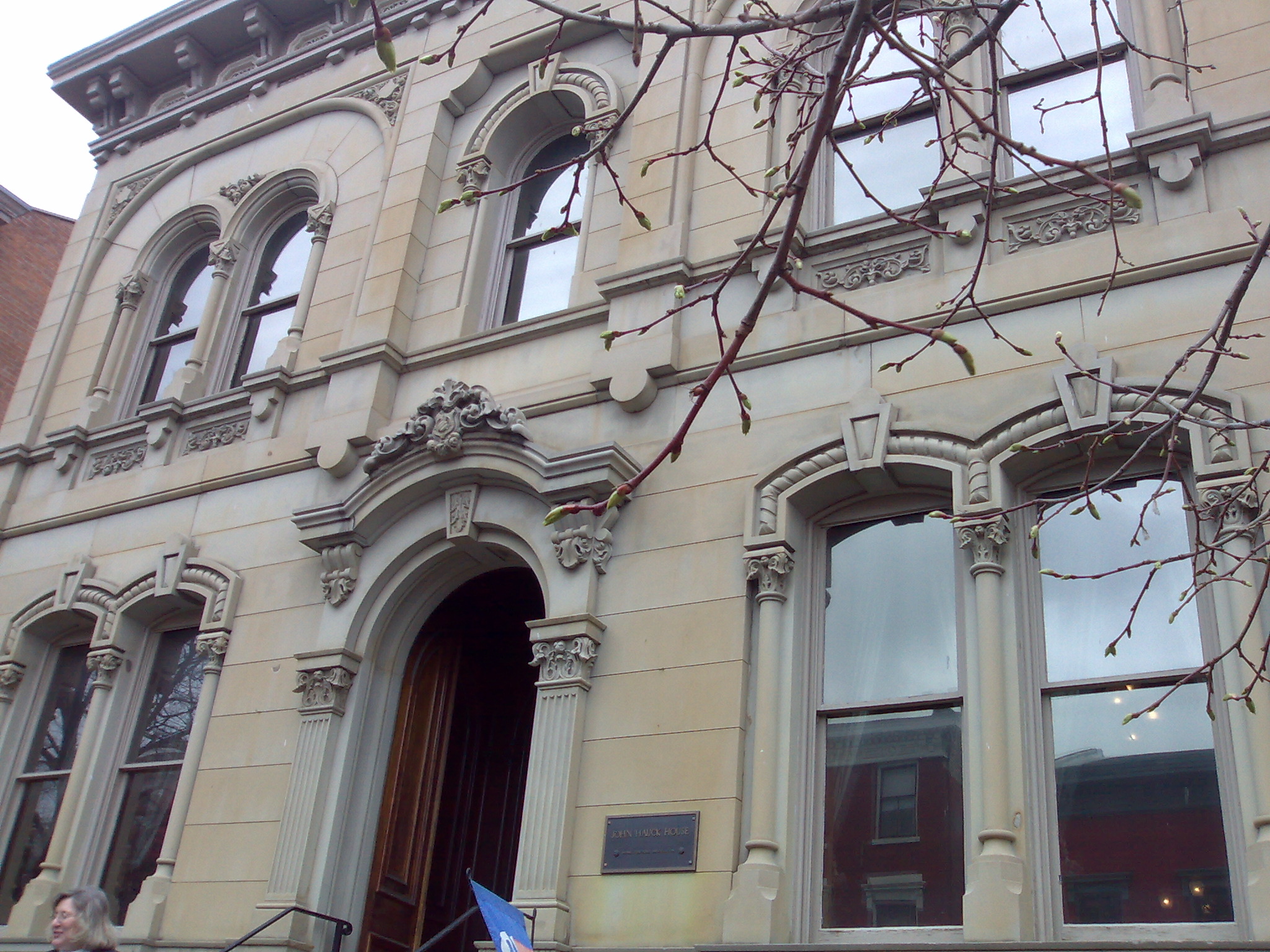 Two-story Italianate stone building with arched windows and ornate decorative cornices.