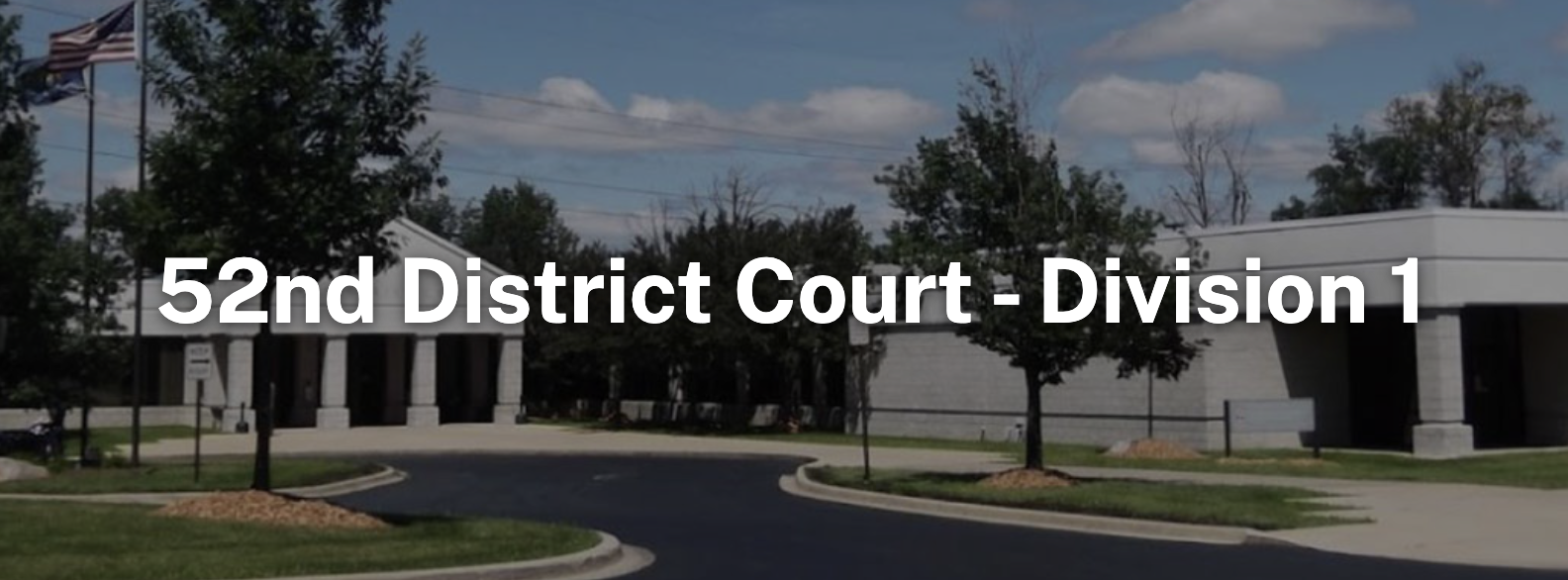 Banner photo of the 52nd District Court, Division 1 building exterior with an American flag and Michigan flag, a curved paved driveway, and landscaped lawn, with white text overlay reading "52nd District Court - Division 1."