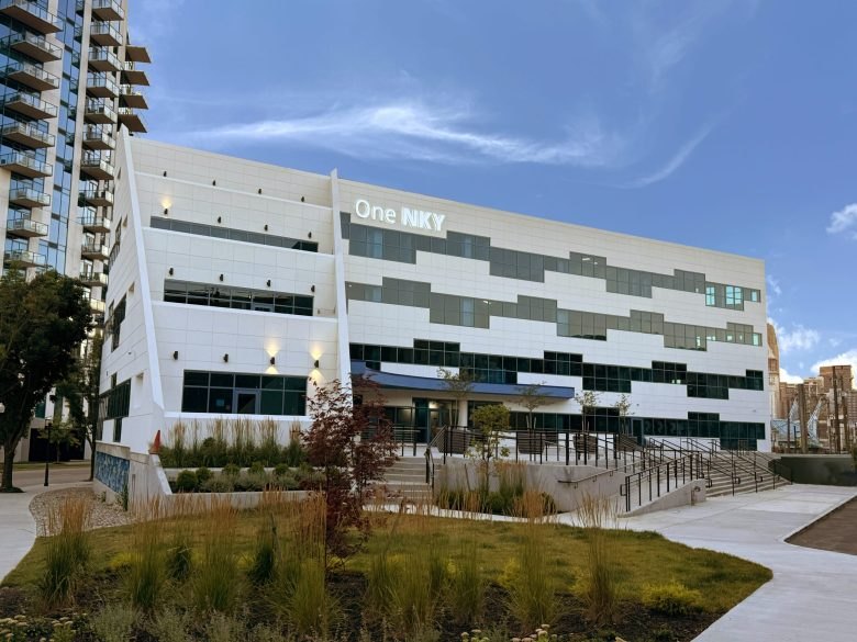 Modern multi-story commercial building with white paneling and a sign reading 'One NKY.'