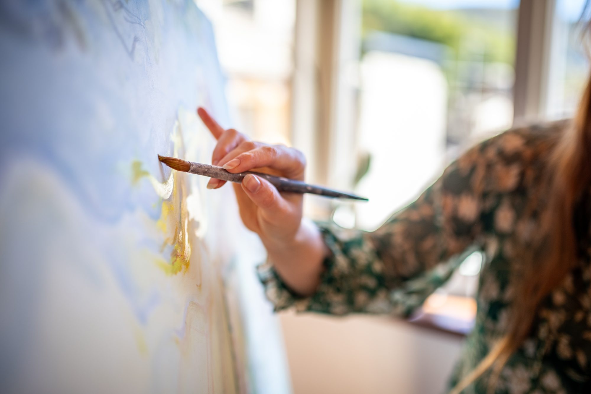 Painter artist young woman in her home studio: Painting canvas