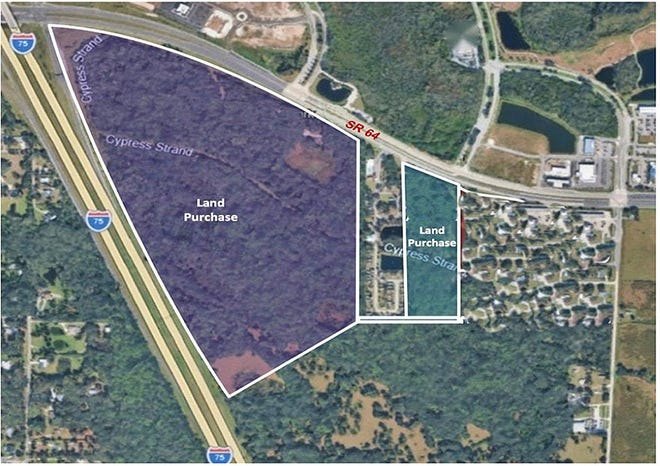 Aerial satellite map showing two highlighted land purchase parcels near an interstate highway interchange.