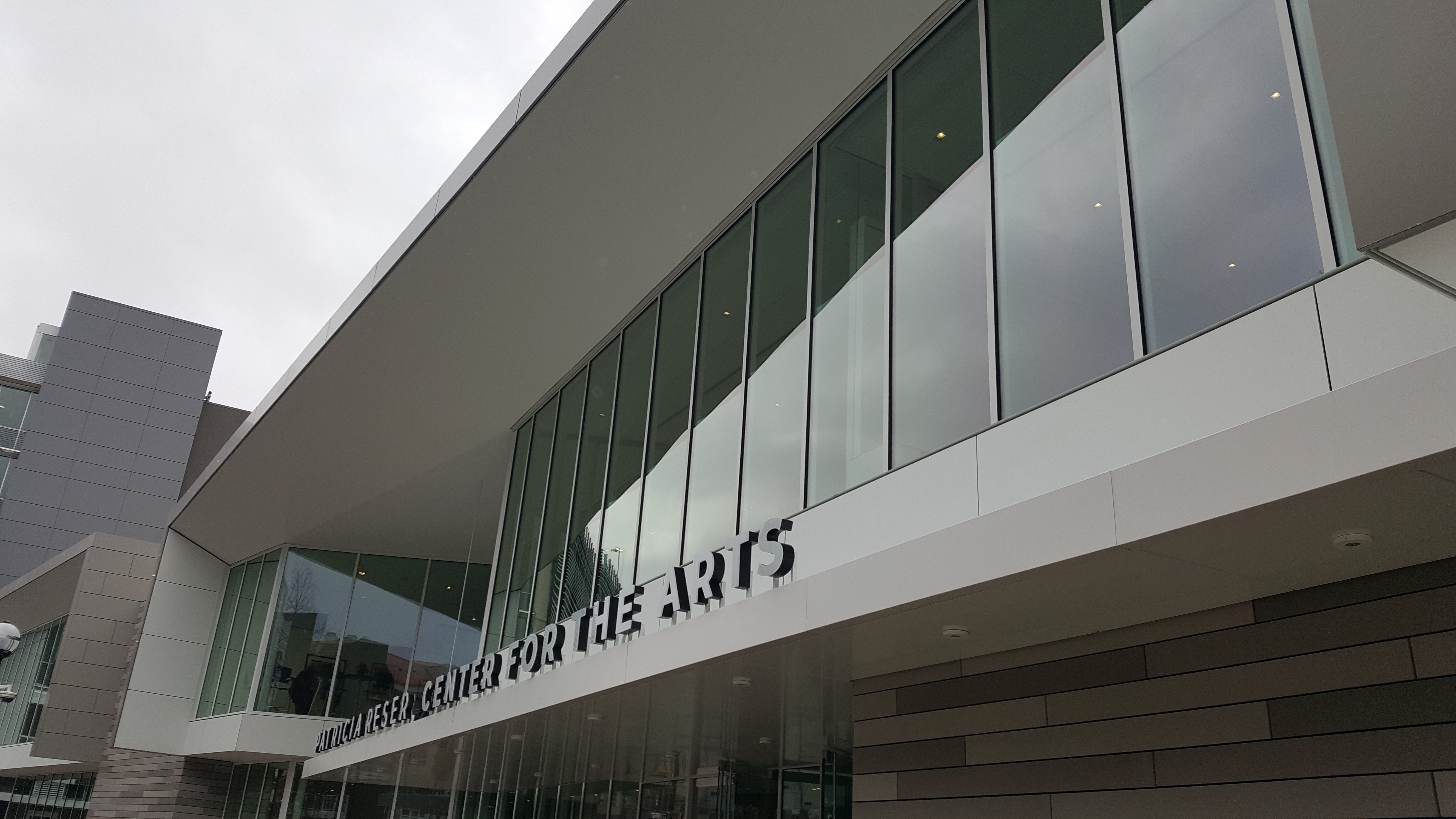 Performing arts center exterior with glass facade and visible 'Center for the Arts' signage.