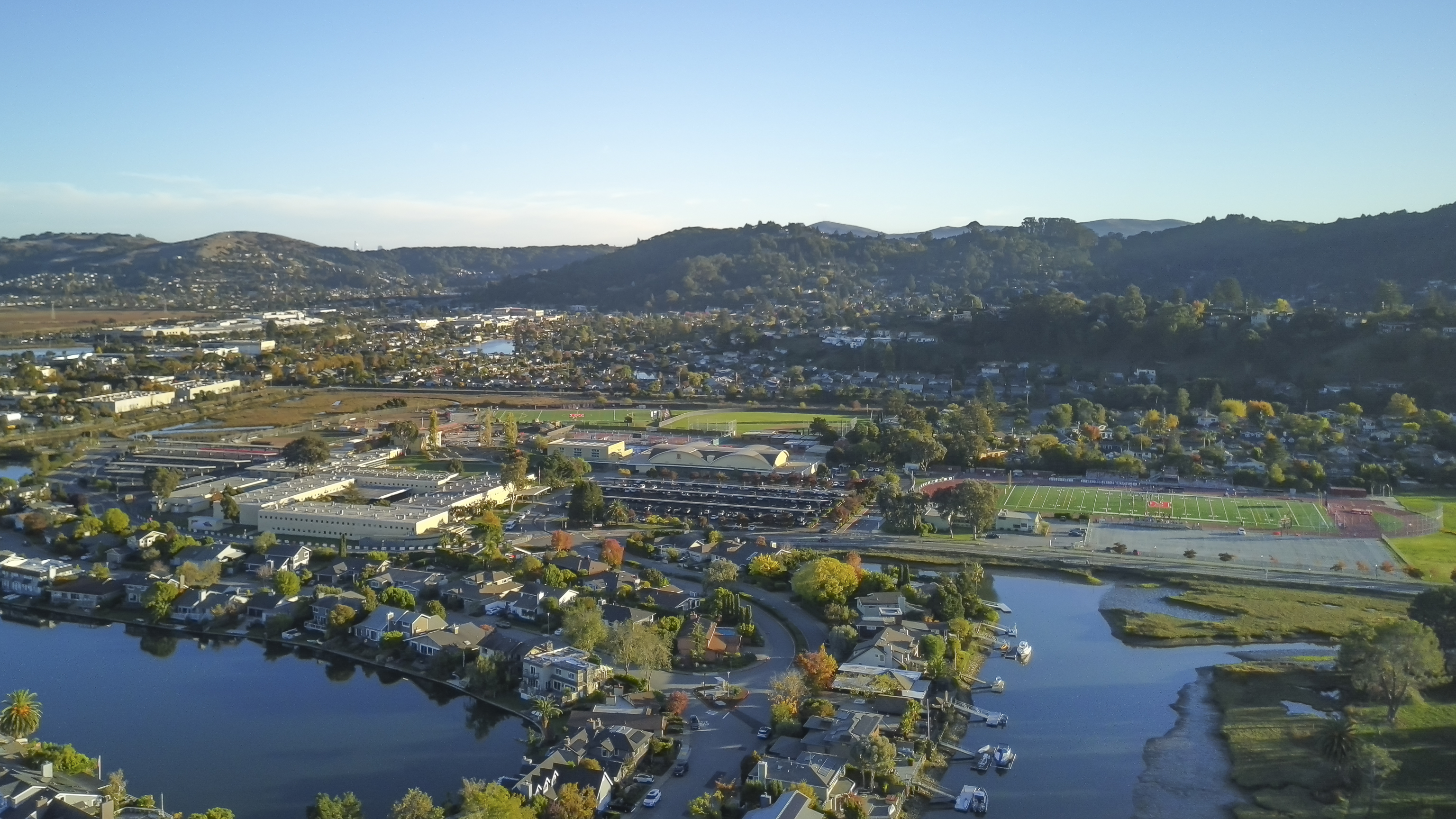 Aerial view of a high school campus with athletic fields, surrounded by neighborhoods and hills.