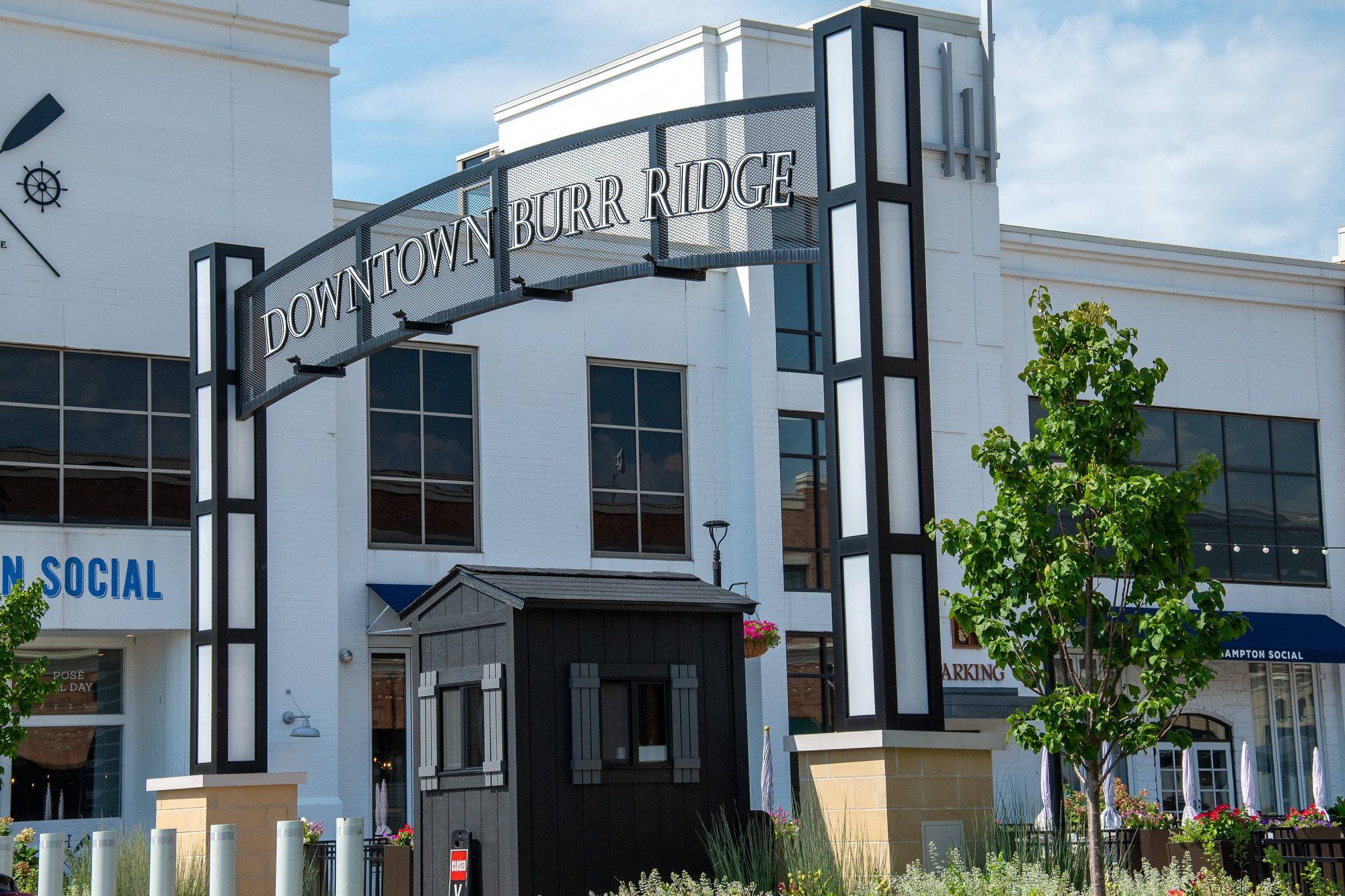 Black-and-white entrance arch marking the gateway to an outdoor shopping and dining district.