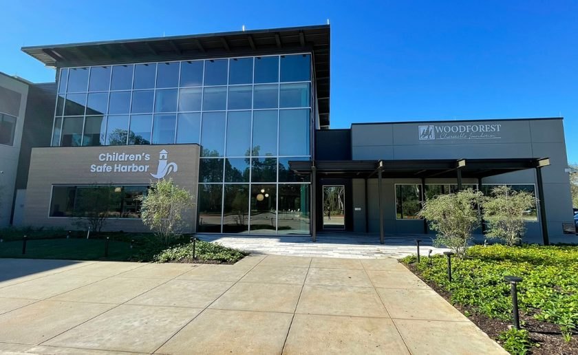 Modern two-story glass-fronted building with Children's Safe Harbor signage and landscaped walkway.
