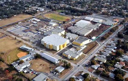 Aerial view of a large school campus with multiple buildings, athletic fields, and surrounding residential streets.