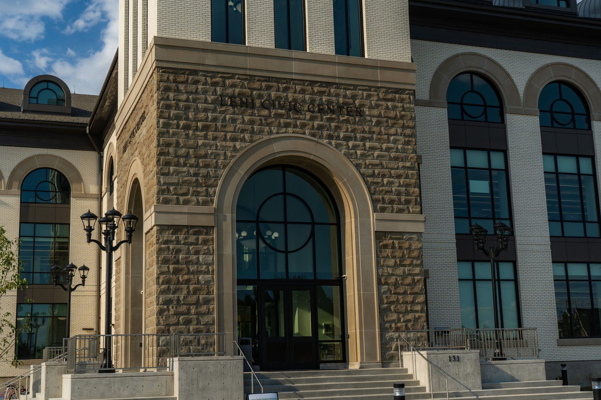 Stone and brick civic building entrance with arched doorway and steps.