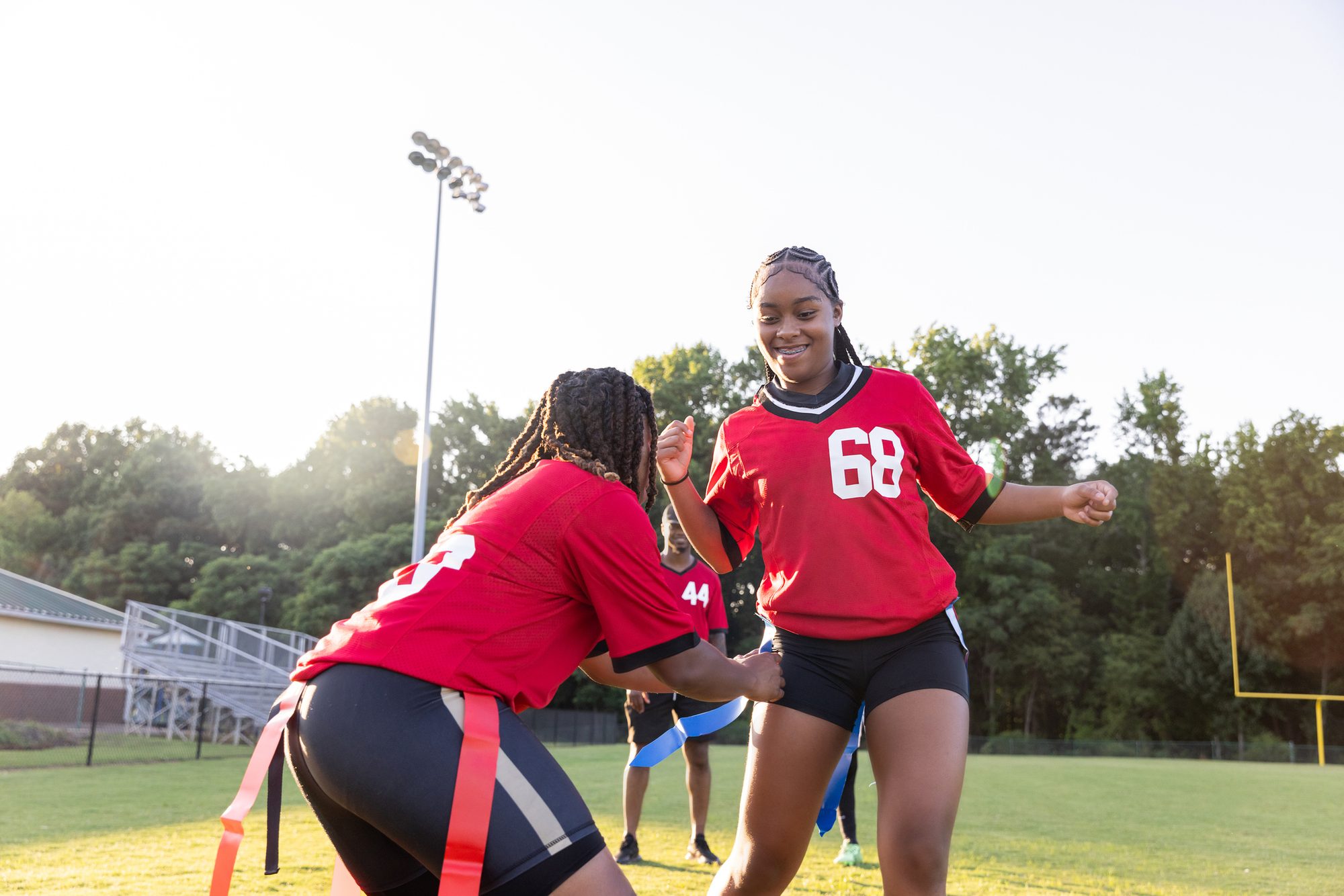 Teenage girls play flag football at high school stadium
