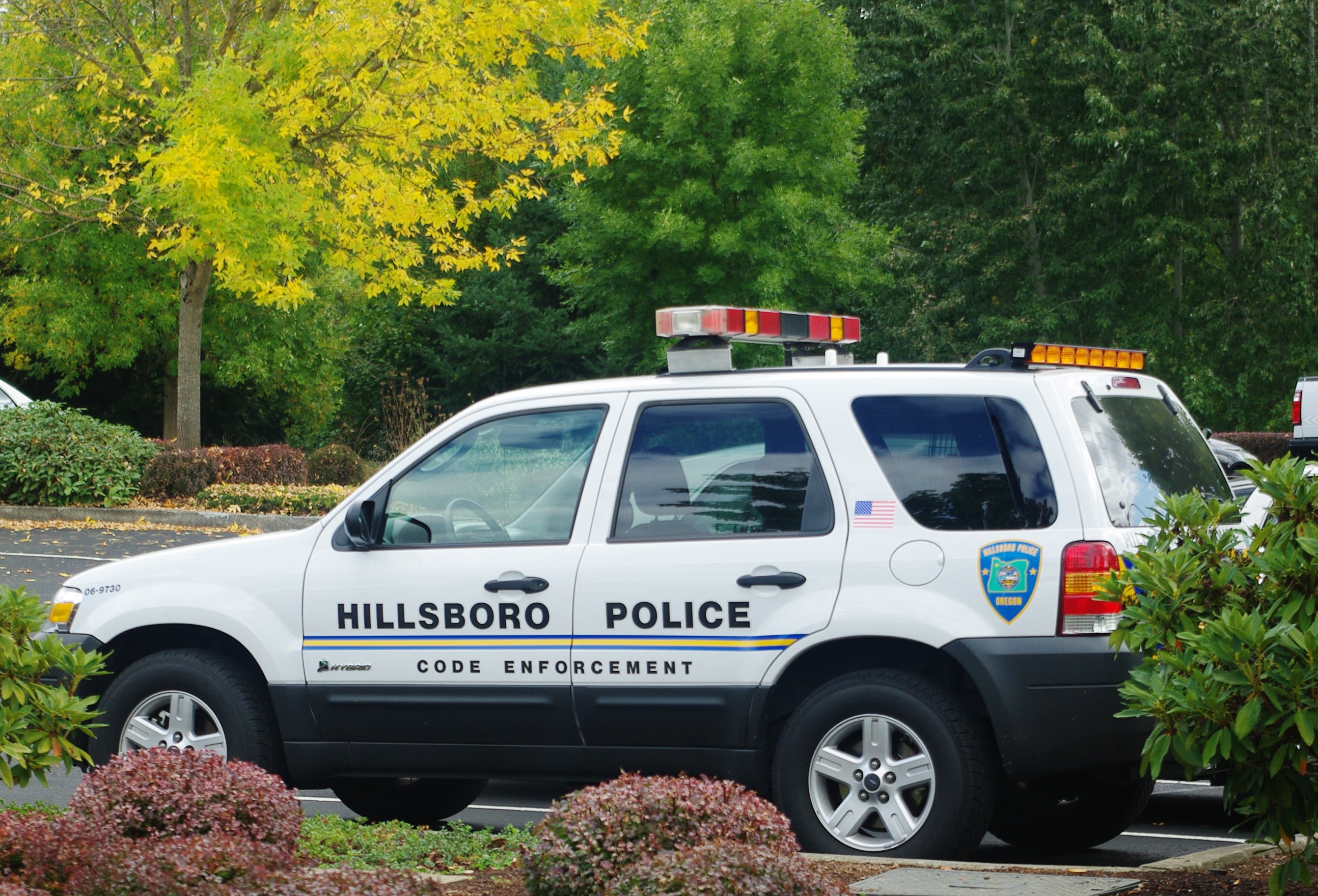 White police SUV marked Code Enforcement with emergency lights parked outdoors.