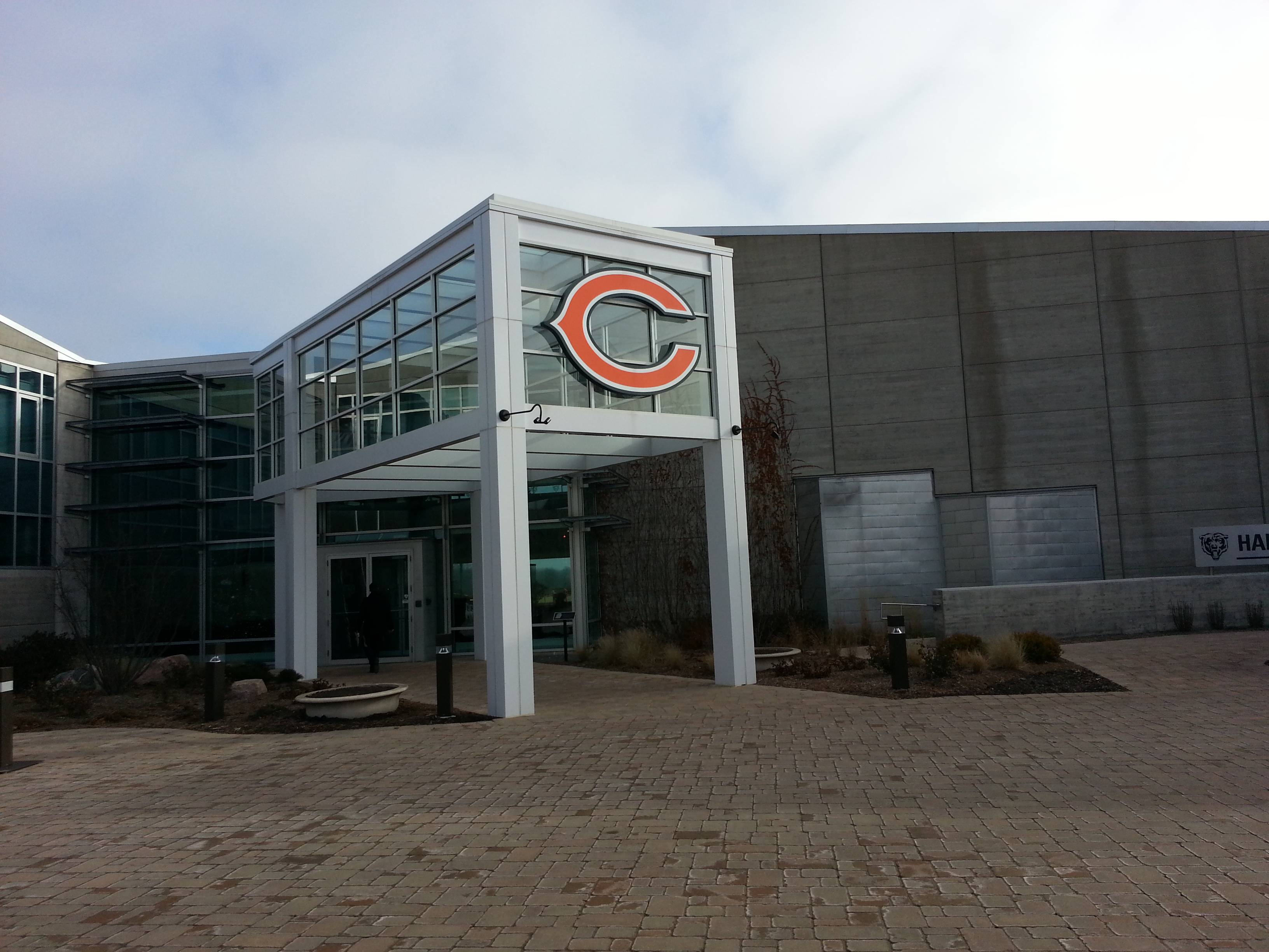 Exterior of a modern building with a large orange Bears logo at the entrance.