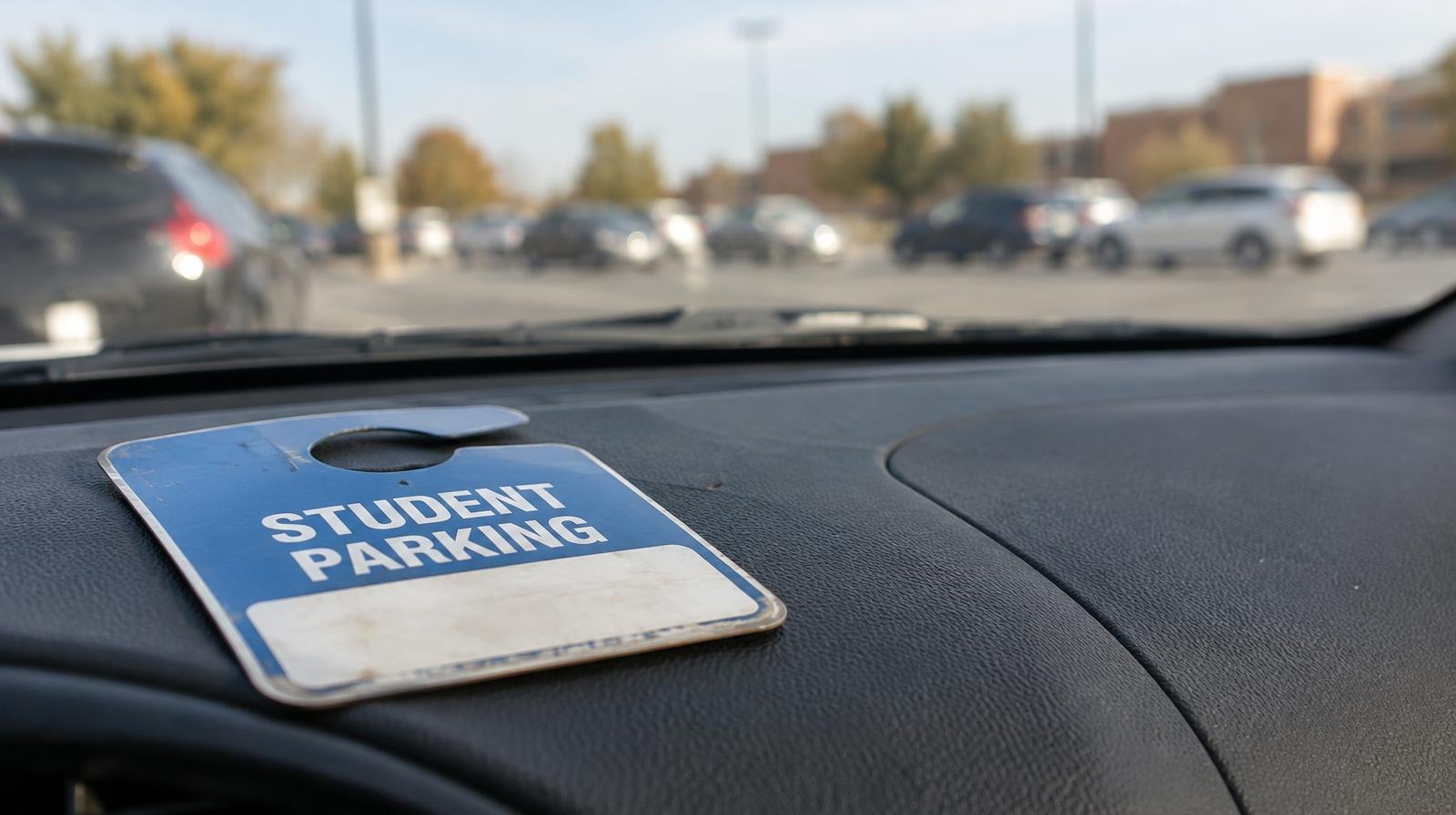 A parking permit hang tag resting on a car dashboard near the windshield.