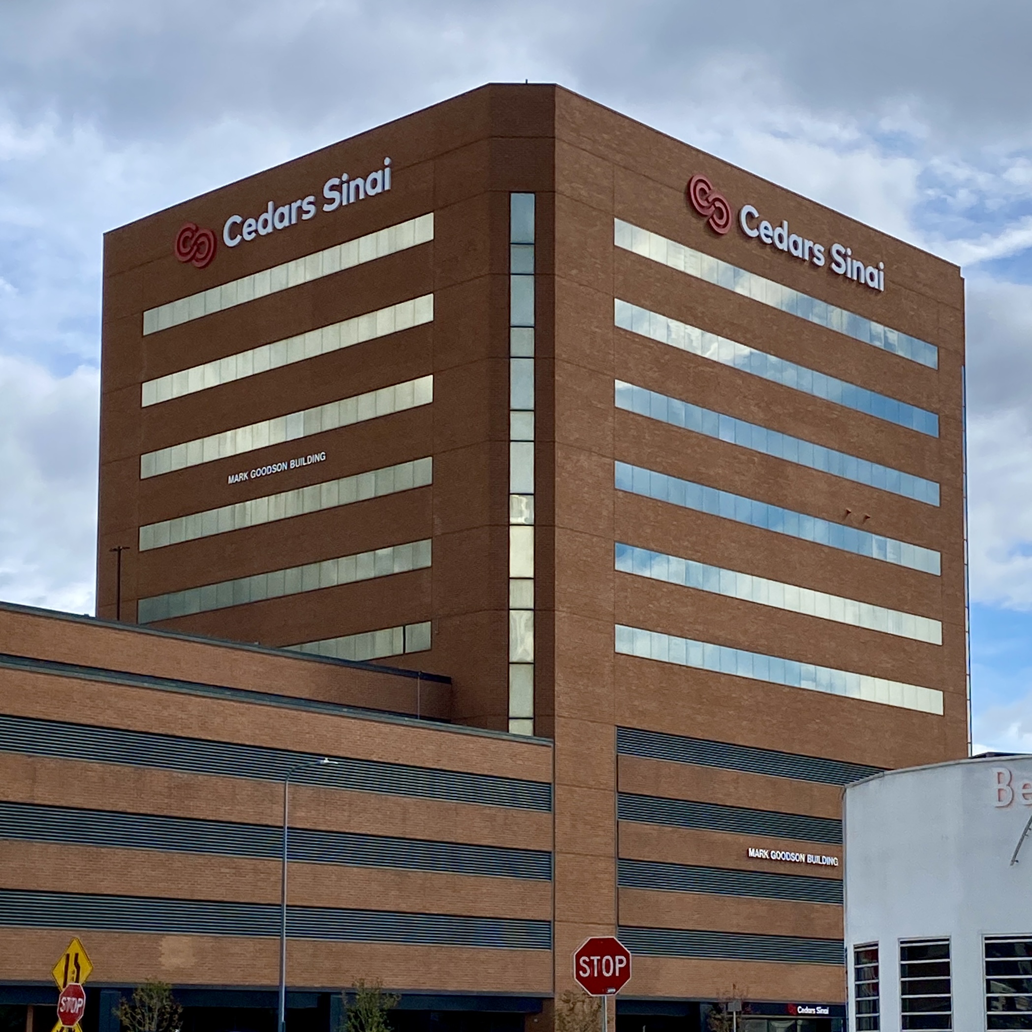 Tall brick hospital building with Cedars-Sinai signage on two sides.