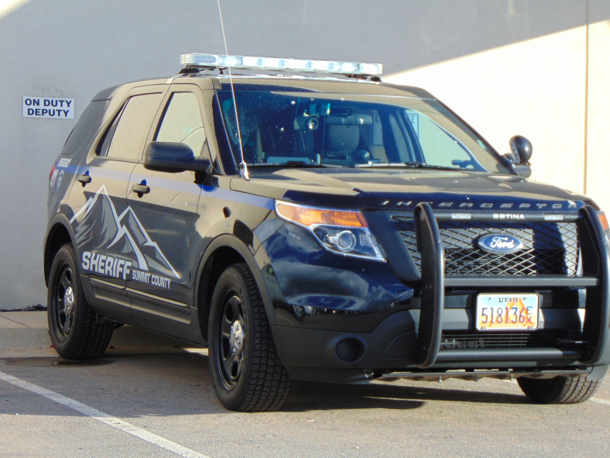 Marked Summit County Sheriff's Office SUV with light bar and push bumper parked indoors.