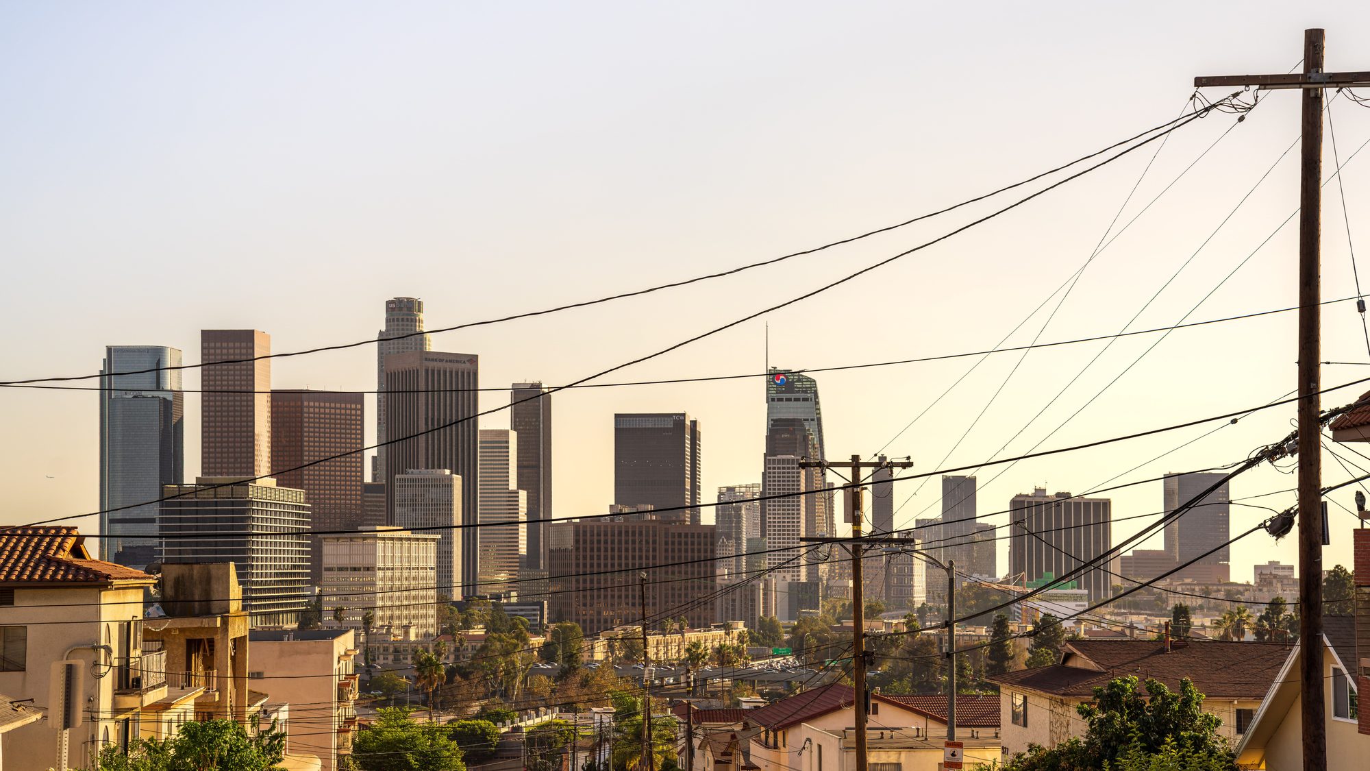 Capture of downtown Los Angeles skyline under a warm sunset, showcasing iconic skyscrapers and urban landscape.