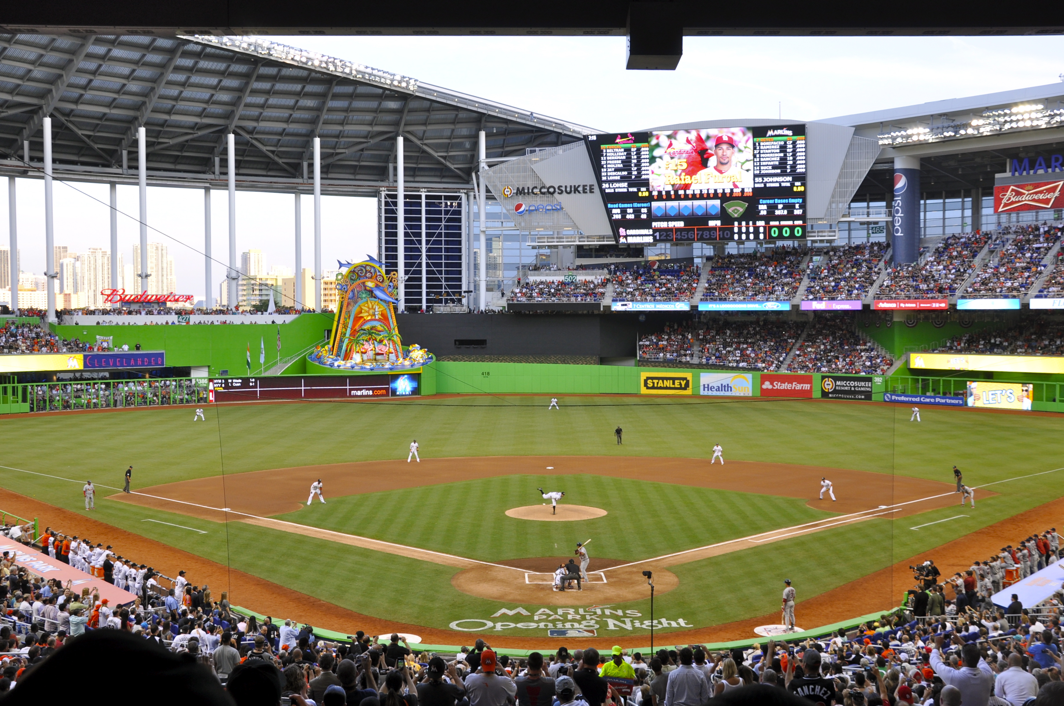 Wide-angle view of Marlins Park during a game, showing the field, retractable roof, and crowded stands.