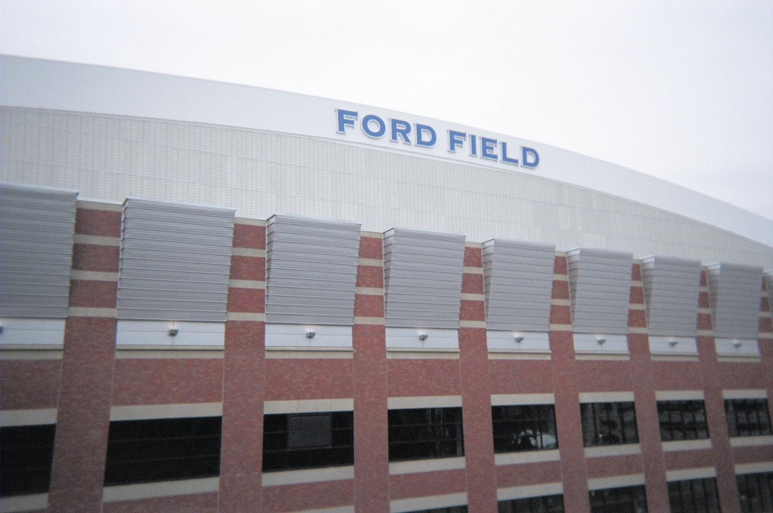 Ford Field stadium exterior with brick facade and large signage under an overcast sky.