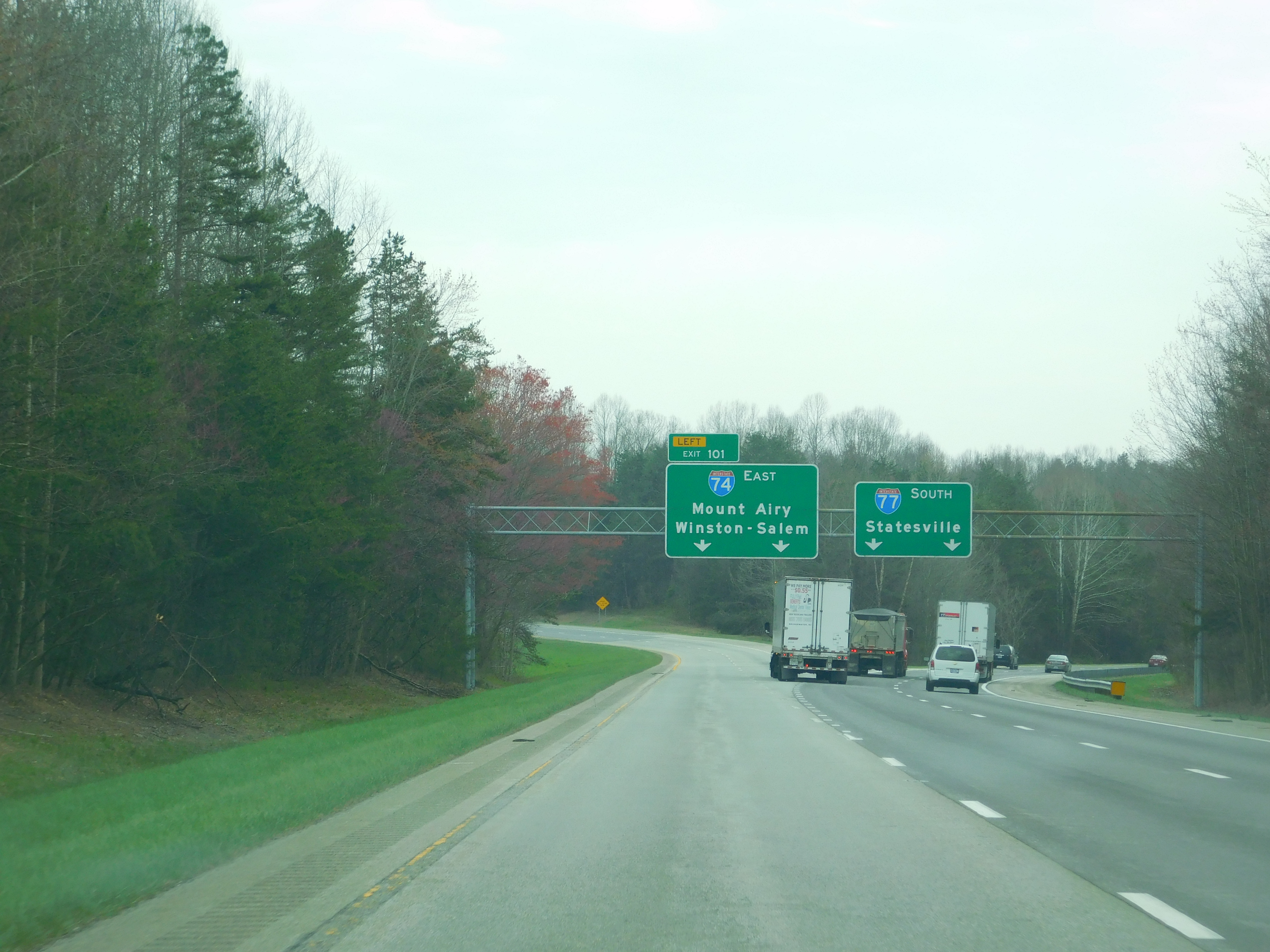 Multi-lane highway with green overhead signs directing traffic toward Statesville on I-77 South.