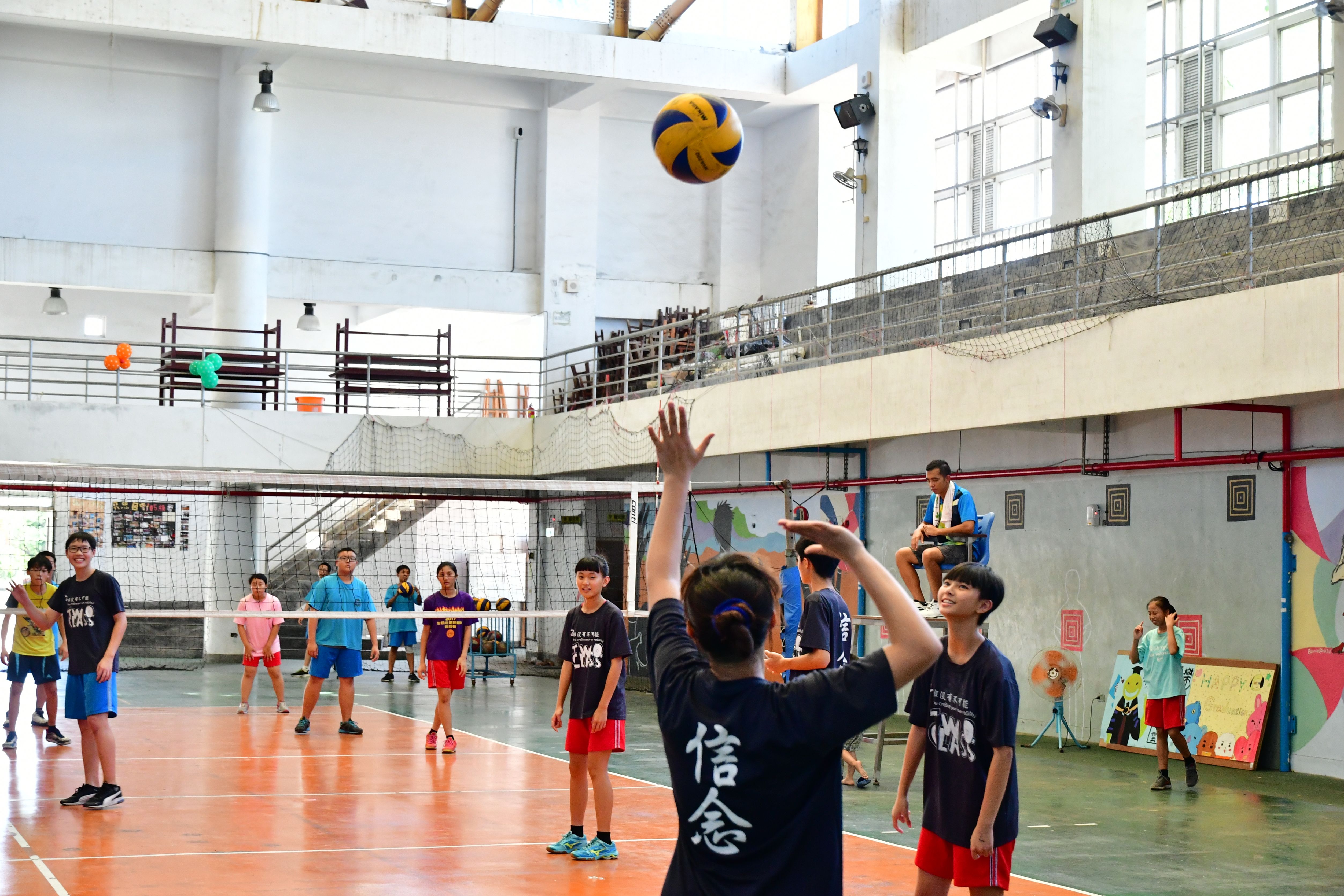 Players competing in an indoor volleyball match near the net.