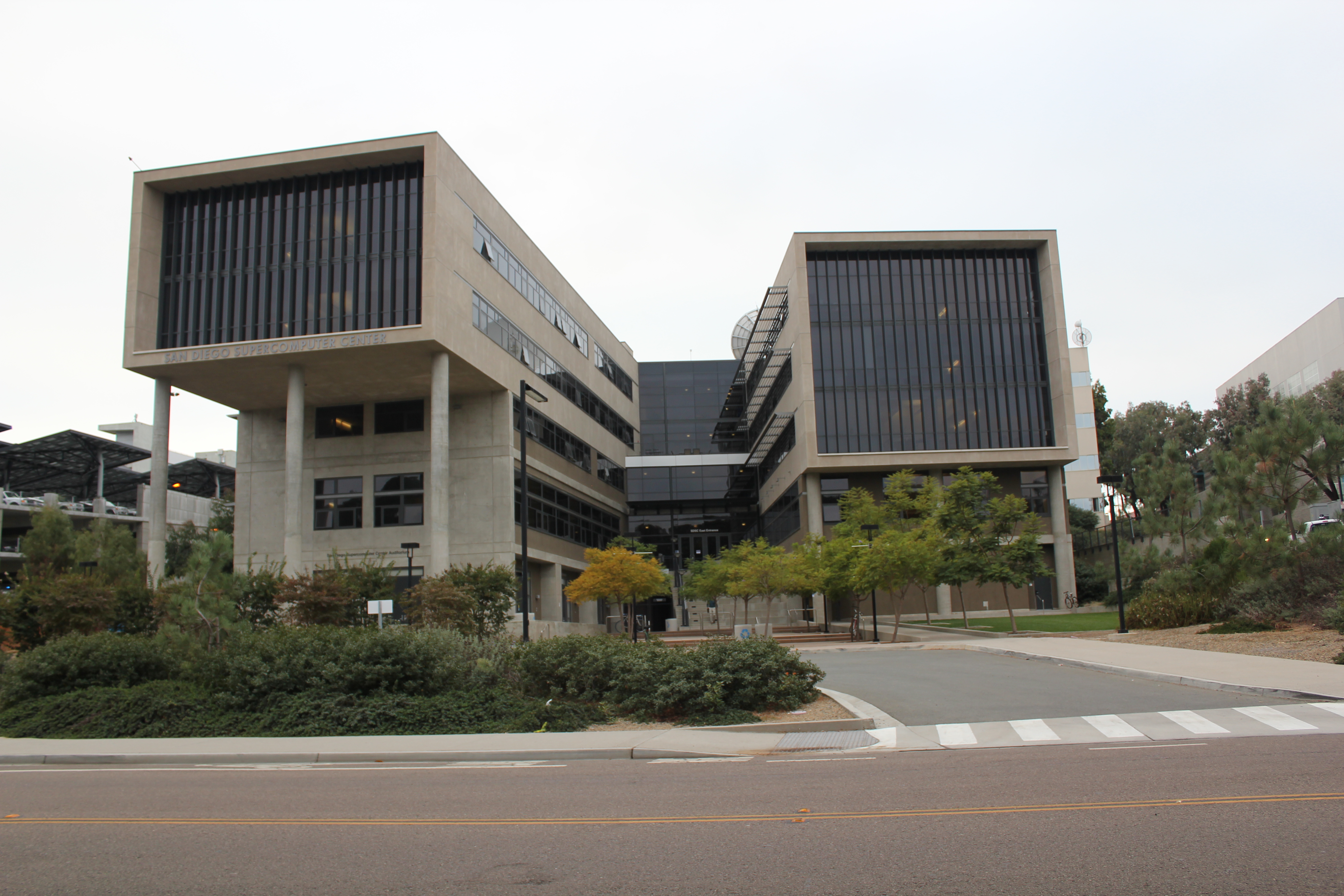Modernist concrete and glass building of the San Diego Supercomputer Center on a university campus.