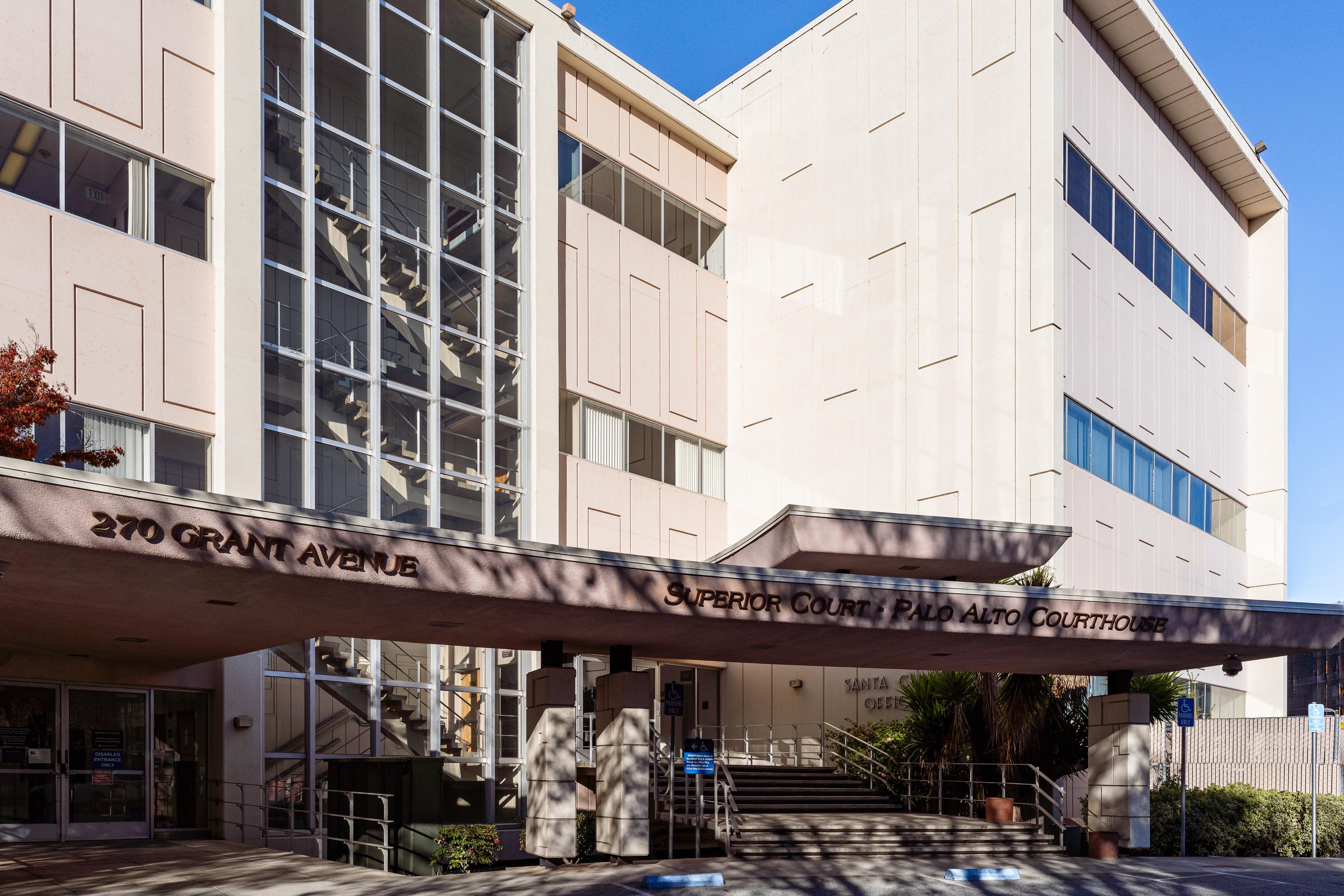 Exterior of a multi-story beige courthouse building with a covered entrance canopy.