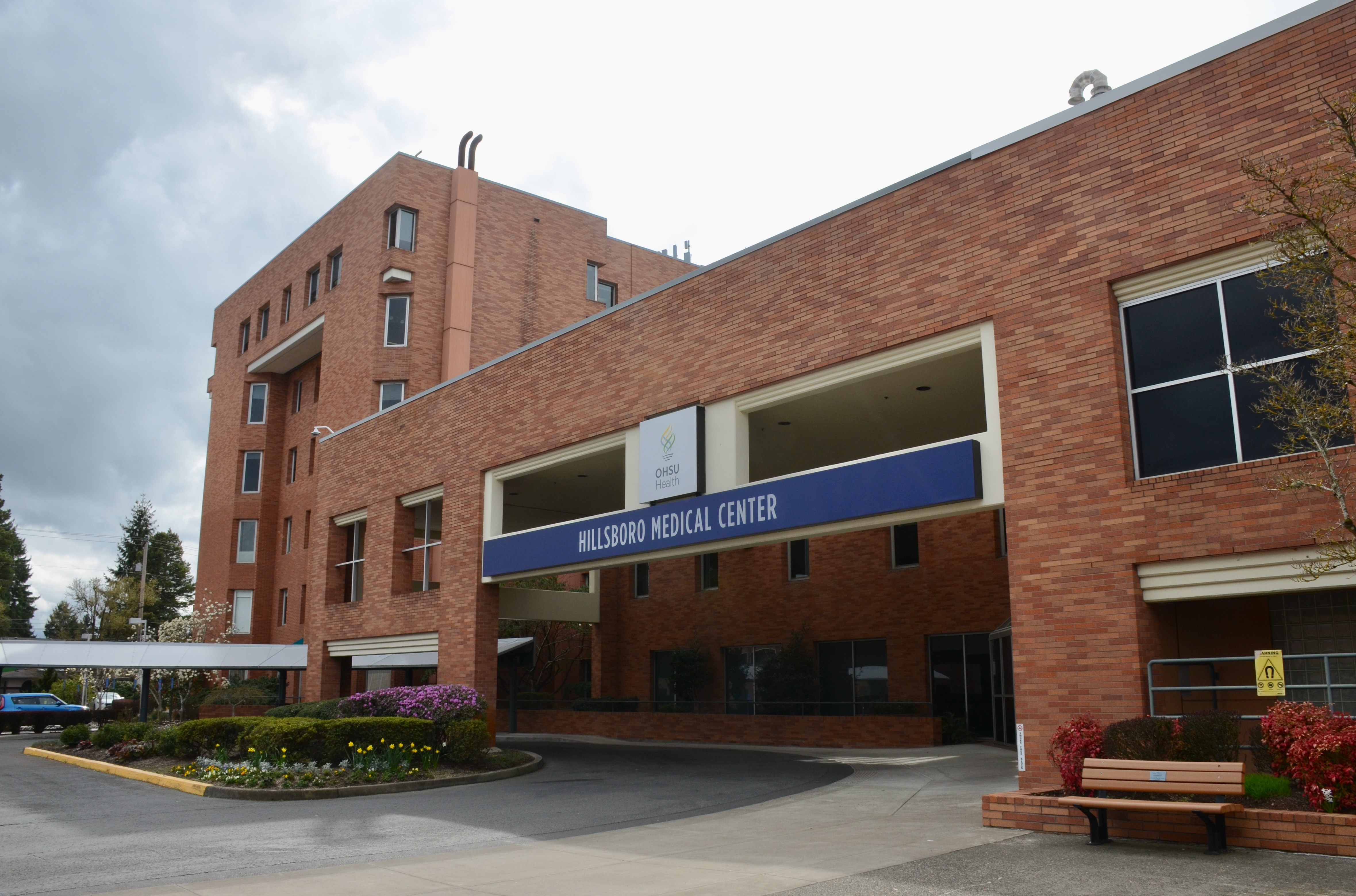 Red brick hospital building with a blue canopy sign reading Hillsboro Medical Center.