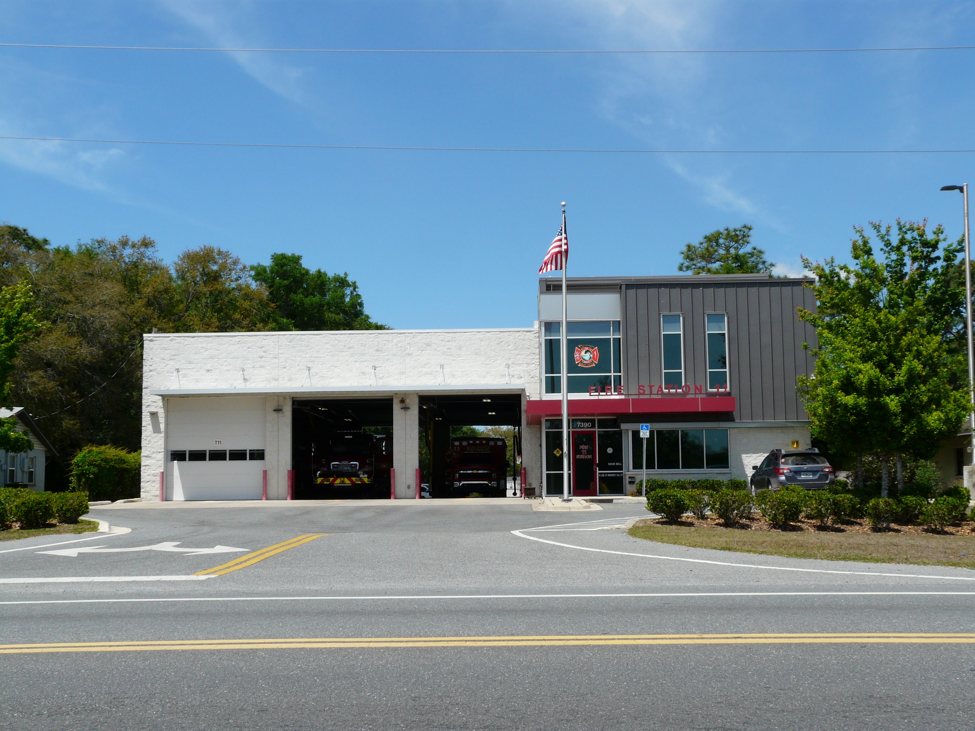Exterior of a Clay County Fire Rescue station with fire trucks visible in open bays.
