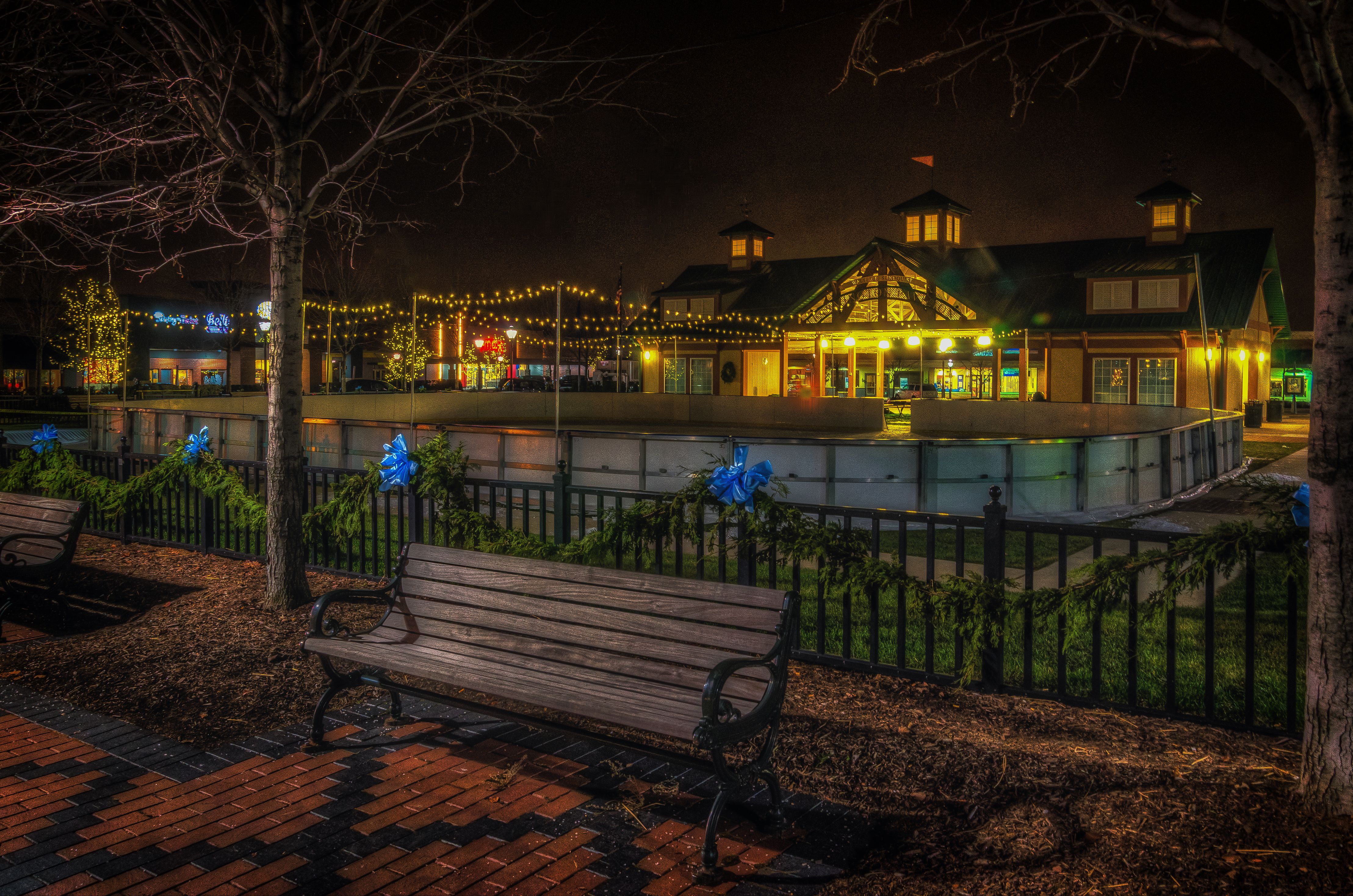 Riley Park at night with a lit pavilion building and string lights in the background.