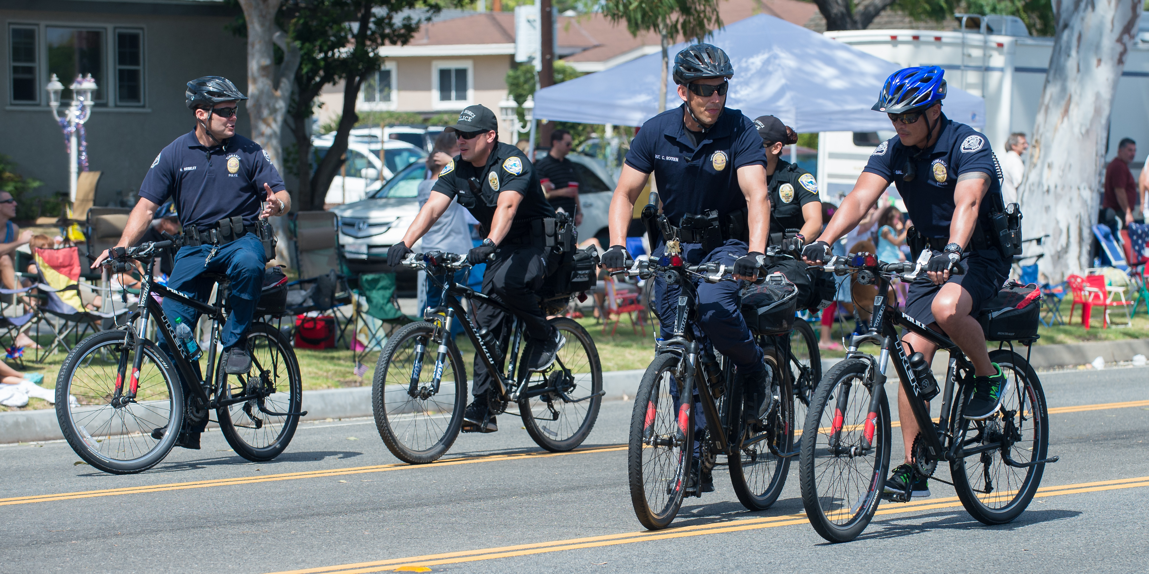 A black-and-white Torrance Police Department patrol car drives on a street.