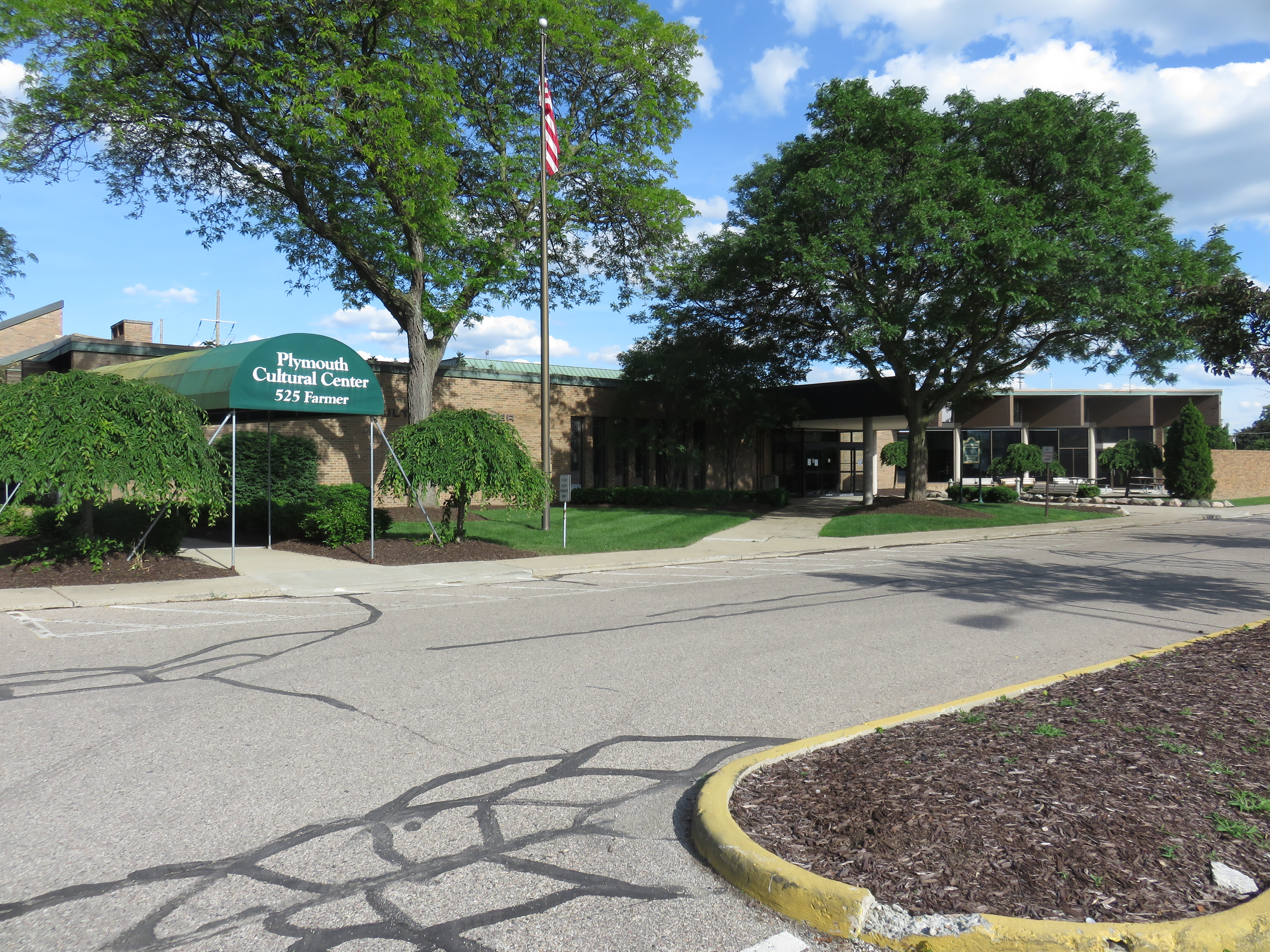 Exterior of a low-profile building with a green awning reading Plymouth Cultural Center.