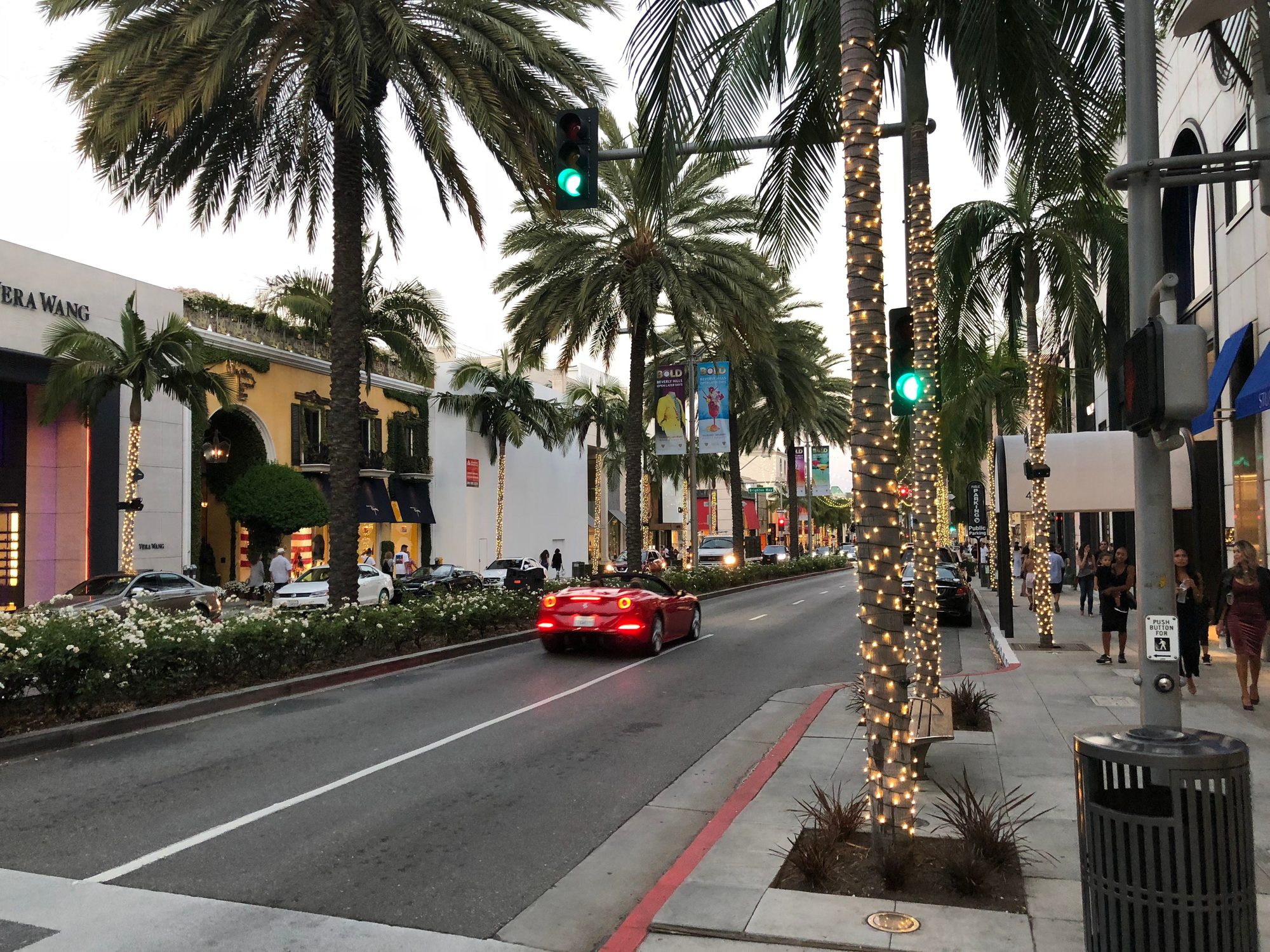 Captivating view of Rodeo Drive with palm trees and luxury shops at dusk in Beverly Hills.