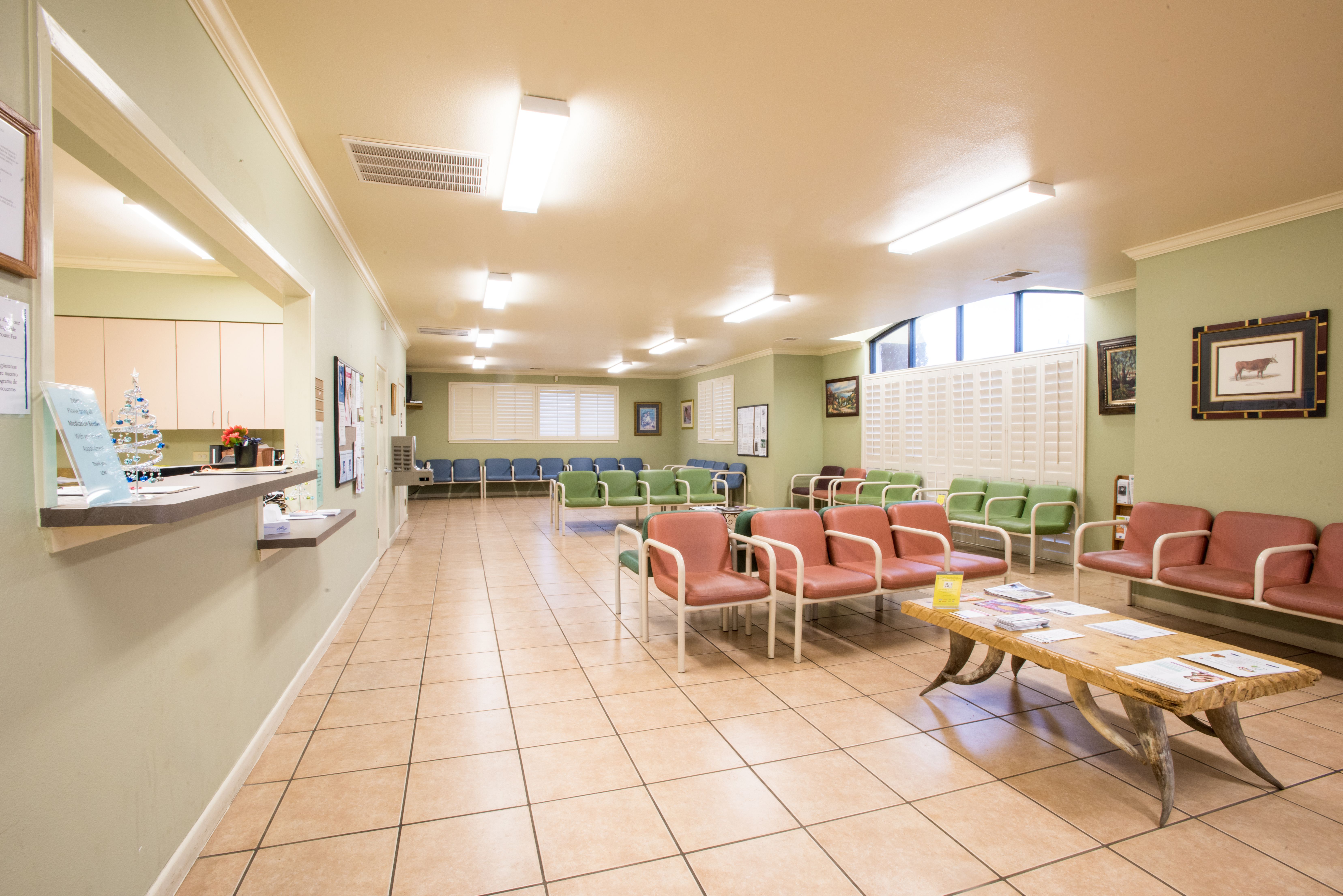 Rows of pink and green chairs fill a community health center waiting room.