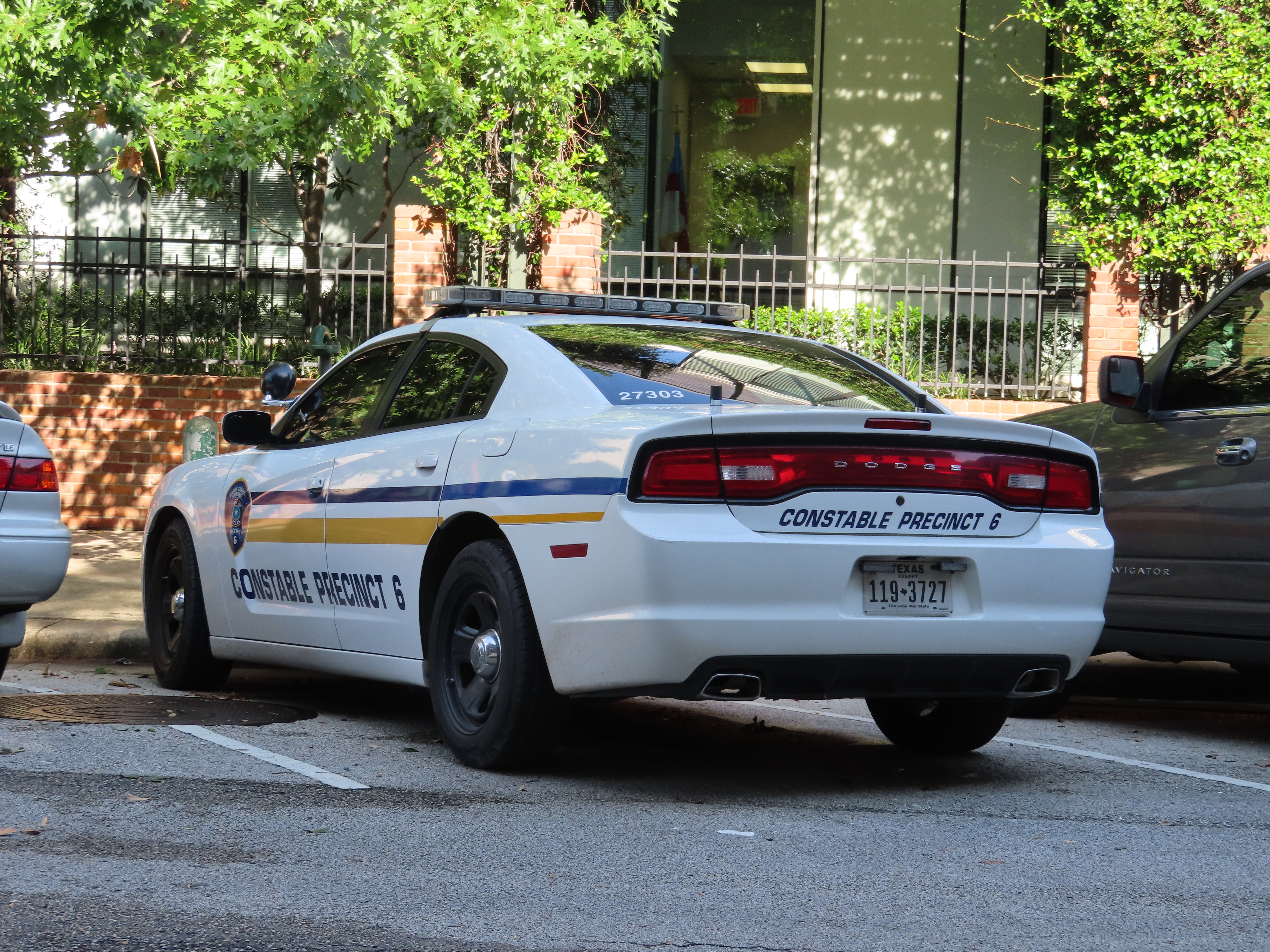 White Dodge Charger patrol car marked Constable Precinct 6 with Harris County badge on the door.