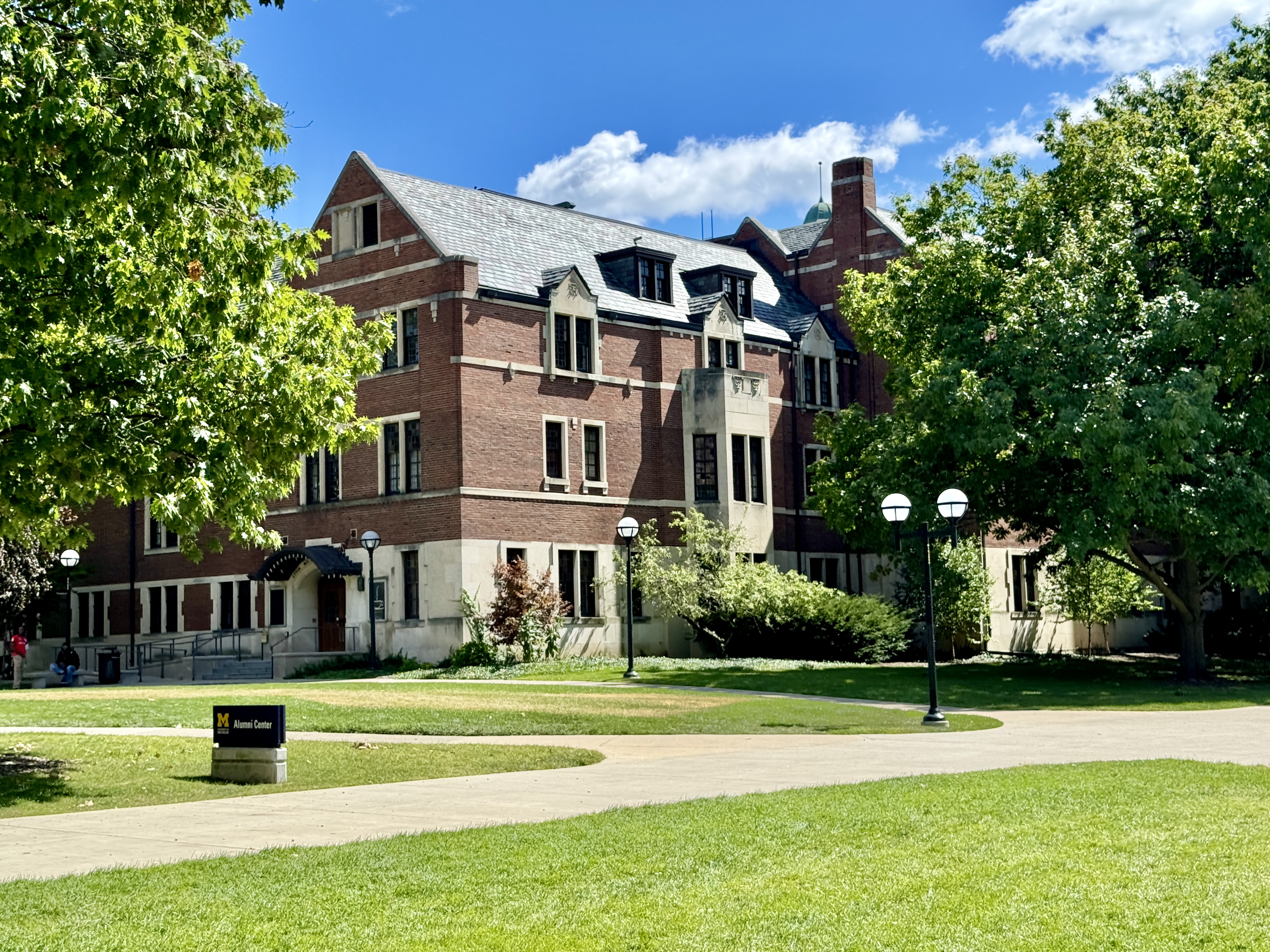 Red-brick Collegiate Gothic Revival building with a 'Michigan League' sign on a sunny day.